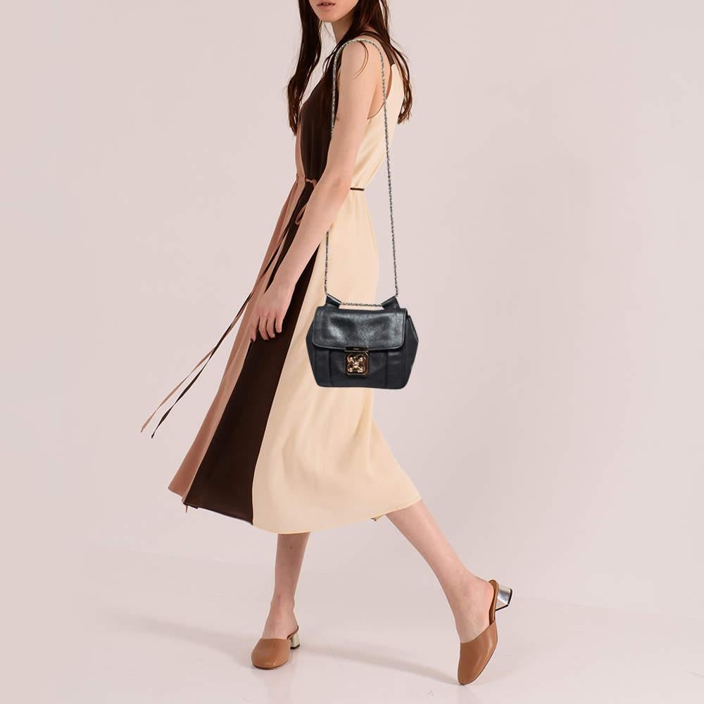 Every curve and detail on this Chloe Elsie is grand which adds to the worth of the bag. It has been crafted from leather and styled with a flap. The bag is secured by a turn-lock revealing a well-sized interior, and completed with a top handle and a