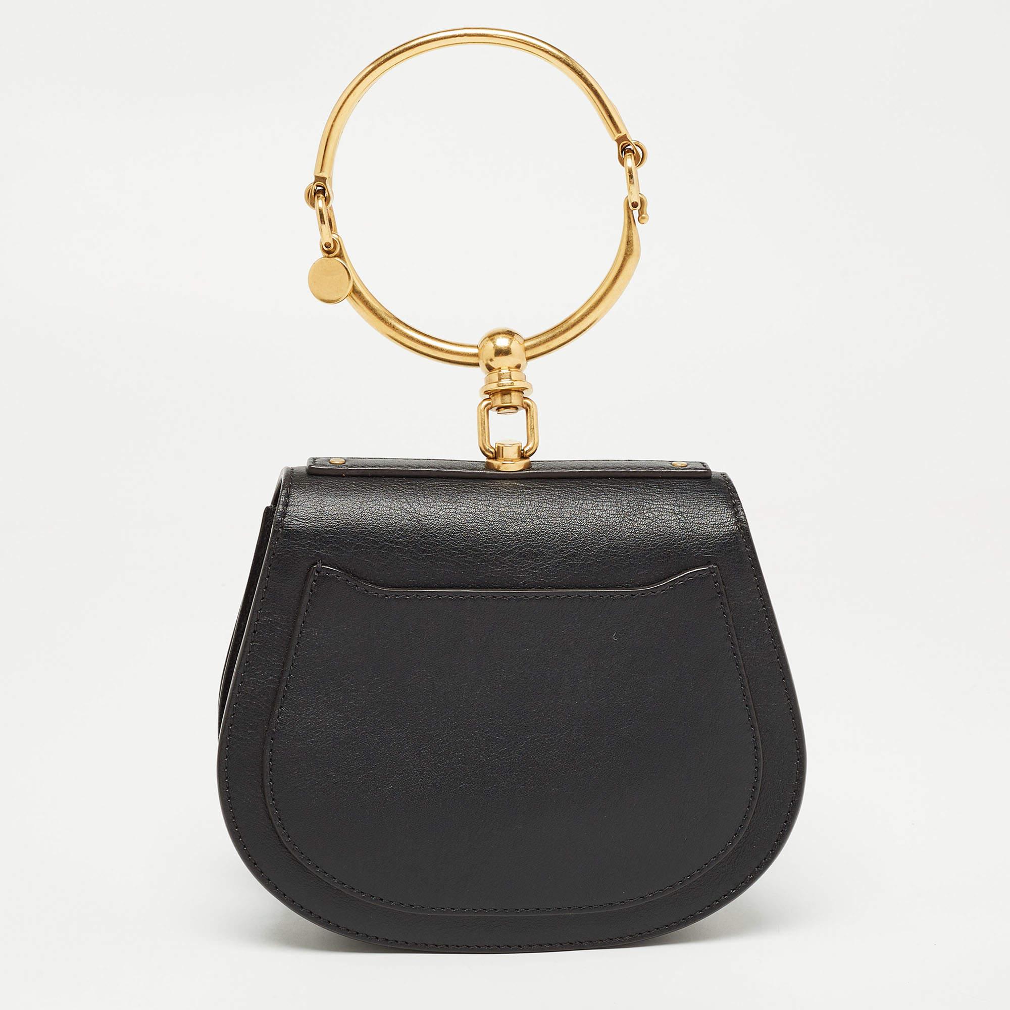 The Chloé Nile Bag is a luxurious and stylish accessory. Crafted from leather, it features intricate stud detailing and a unique bracelet handle. This compact crossbody bag exudes elegance and is perfect for carrying essentials while making a bold
