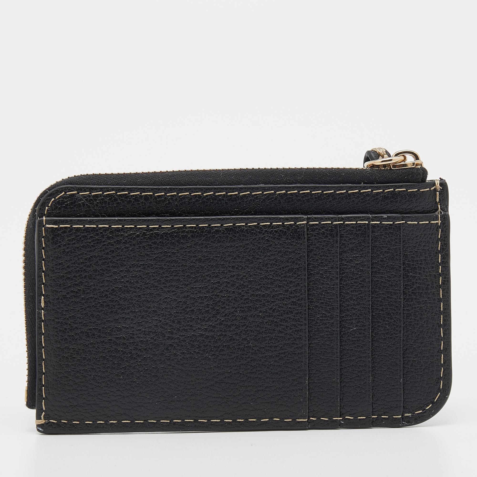 This chic cardholder by Chloe exudes class and sophistication. Crafted from leather, it comes in a black shade. It features a top zip closure, a fabric interior sized to hold your essentials, multiple card slots on the front, and a zip pull. This