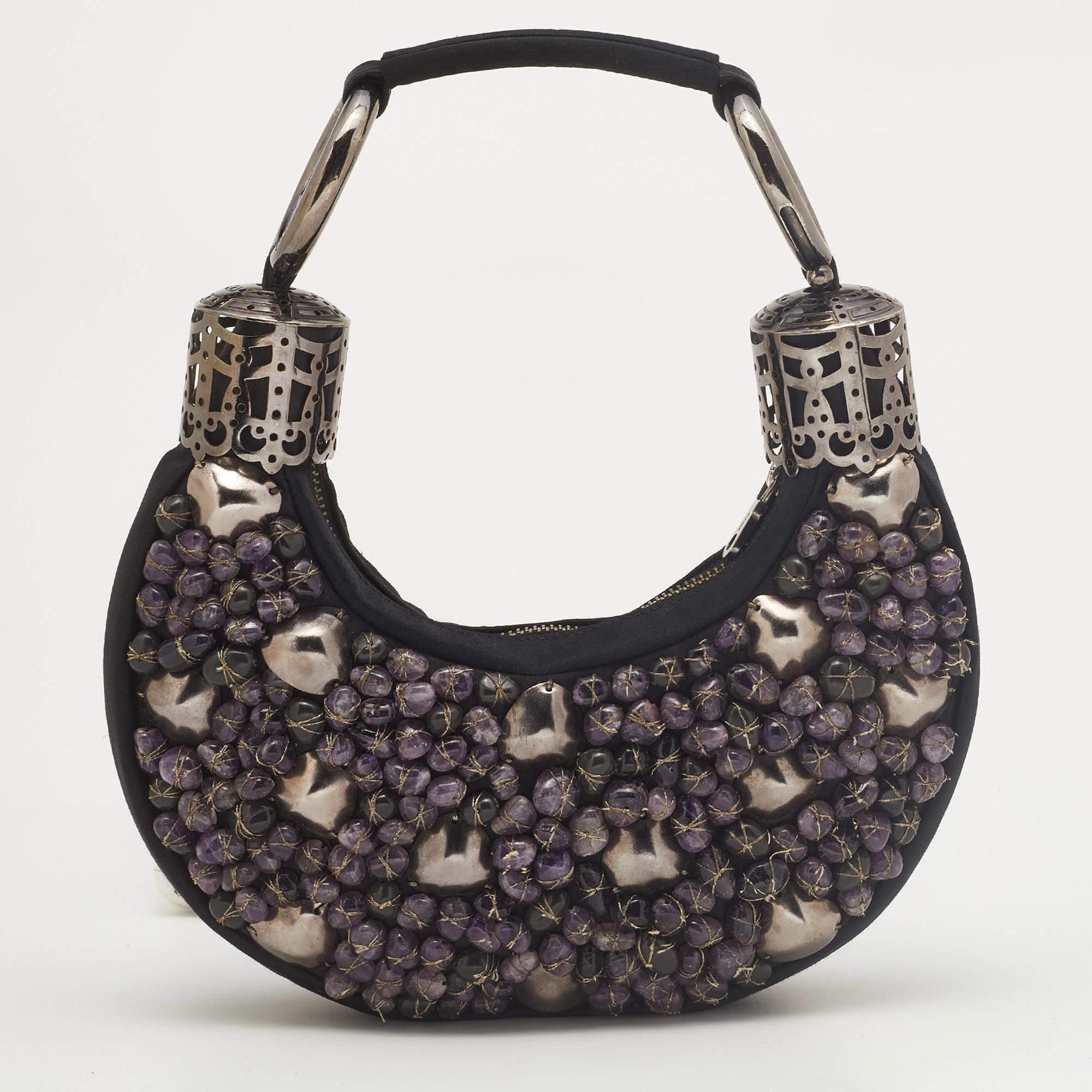 This Chloe design has a black satin exterior with an embellishment of beads and stones. The hobo carries a crescent shape and features a top-zip closure that opens to a satin-lined interior with the brand's label. Raise your glamour quotient by