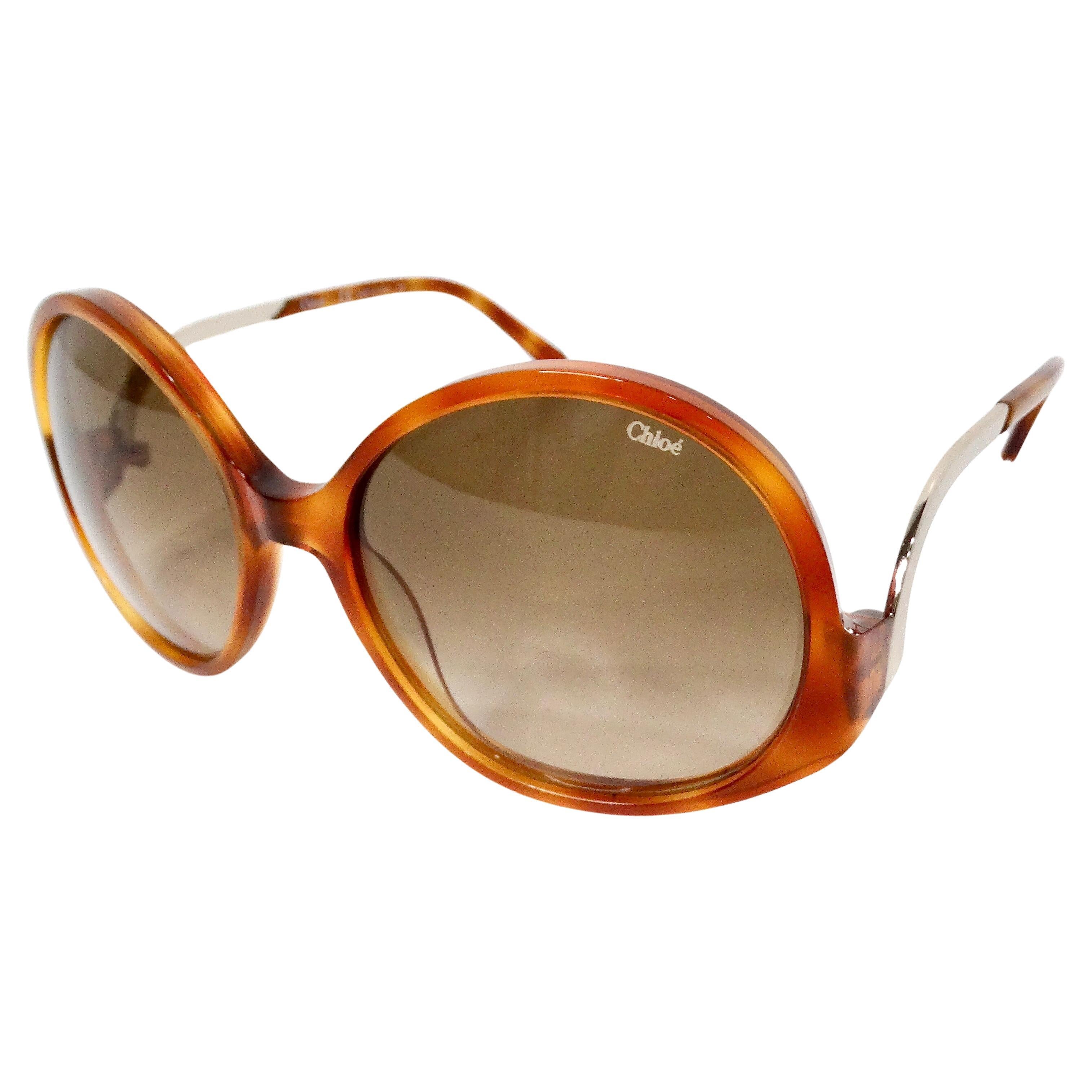 Gli occhiali da sole Chloe Blonde Tortoise Round Oversized sono l'epitome della raffinatezza chic e dell'eleganza senza tempo. Realizzati con una splendida miscela di tartaruga bionda e montatura rotonda oversize, questi occhiali da sole combinano