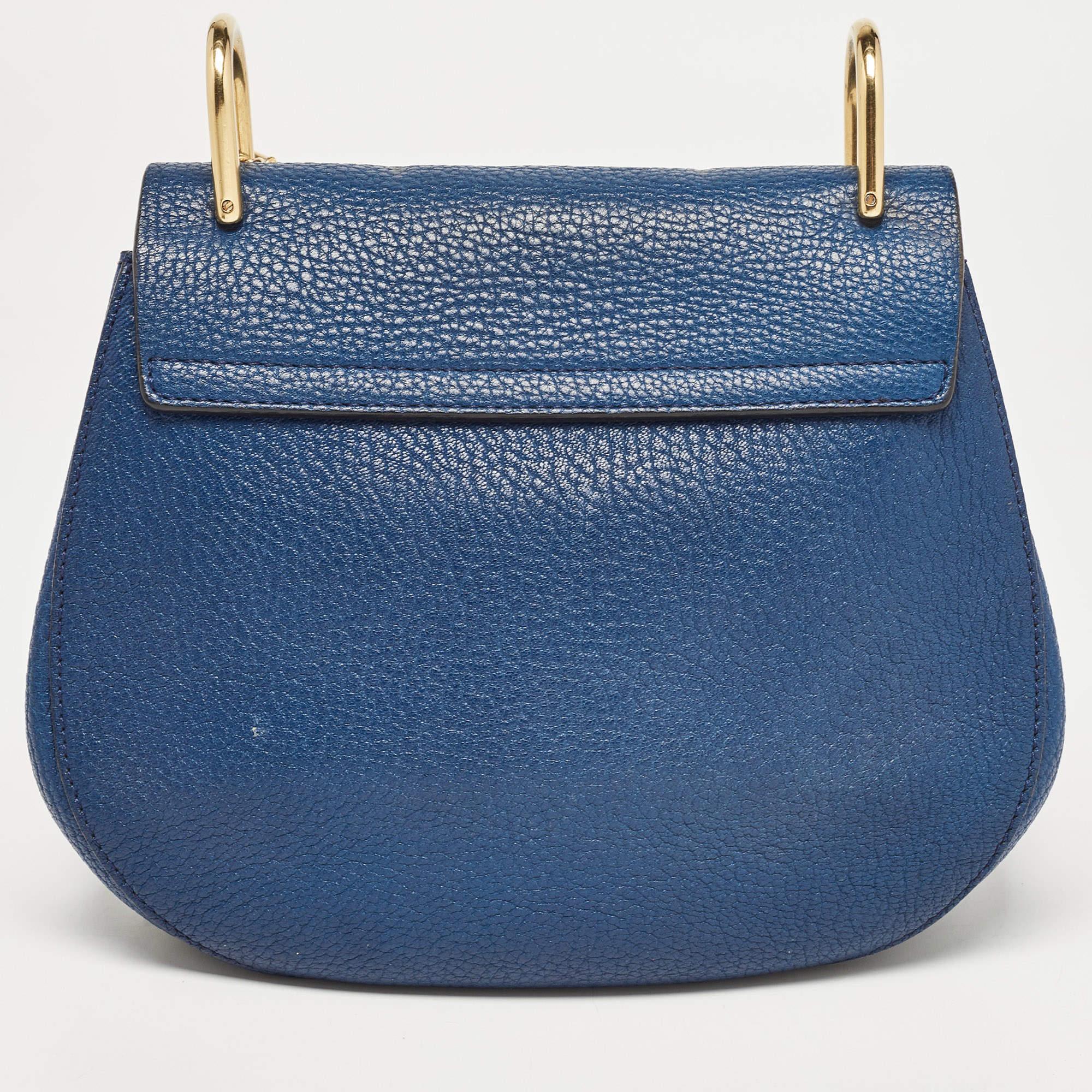 Avec son attrait classique et son design artistique, ce sac Chloé gagnera votre cœur dès le premier regard. Les accents dorés sur l'extérieur de cette création bleue en font une pièce à part dans votre garde-robe. Conçu en cuir, il est doté d'une