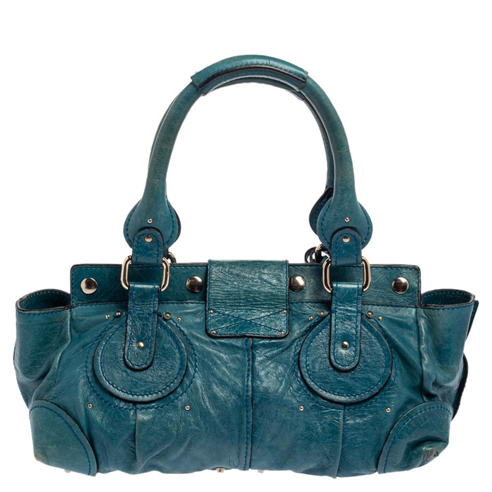 This Chloe Paddington satchel is built to assist your impeccable style on all days. Gold-Tone hardware with a chunky lock on the front easily attracts all the attention. The blue leather exterior has an interesting texture while the fabric interior