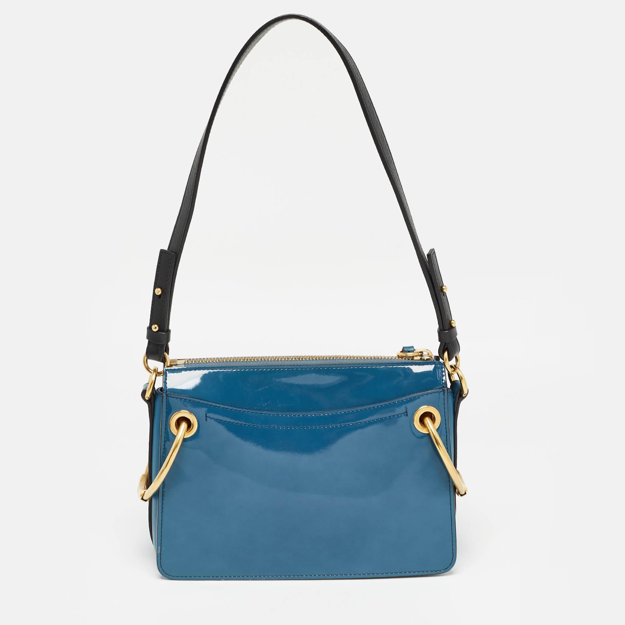 Make a stunning appearance every time you carry this Roy bag by Chloe. Brilliantly designed, this bag is made from blue leather and suede on the exterior and flaunts gold-toned hardware. Swing this beautiful bag with you and fetch nothing but