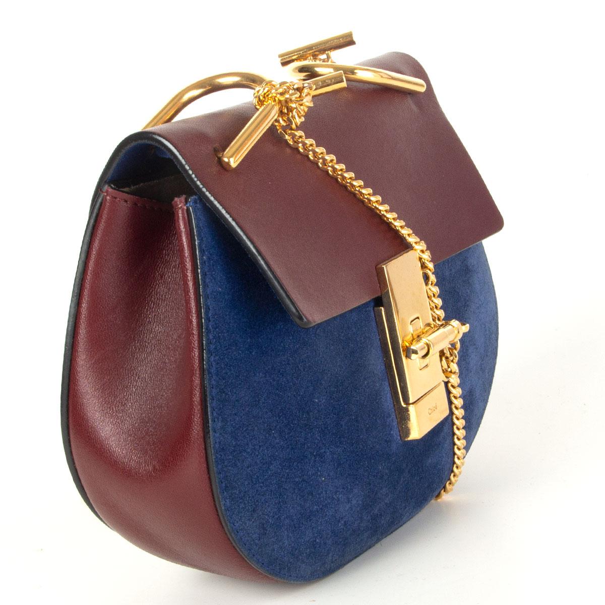 Authentique sac à bandoulière 'Drew Mini' de Chloé en daim bleu et cuir de veau bordeaux, orné de ferrures dorées. Il s'ouvre à l'aide d'un rabat fermé par une épingle et un fermoir. Il n'est pas doublé et comporte une poche ouverte au dos. Elle a