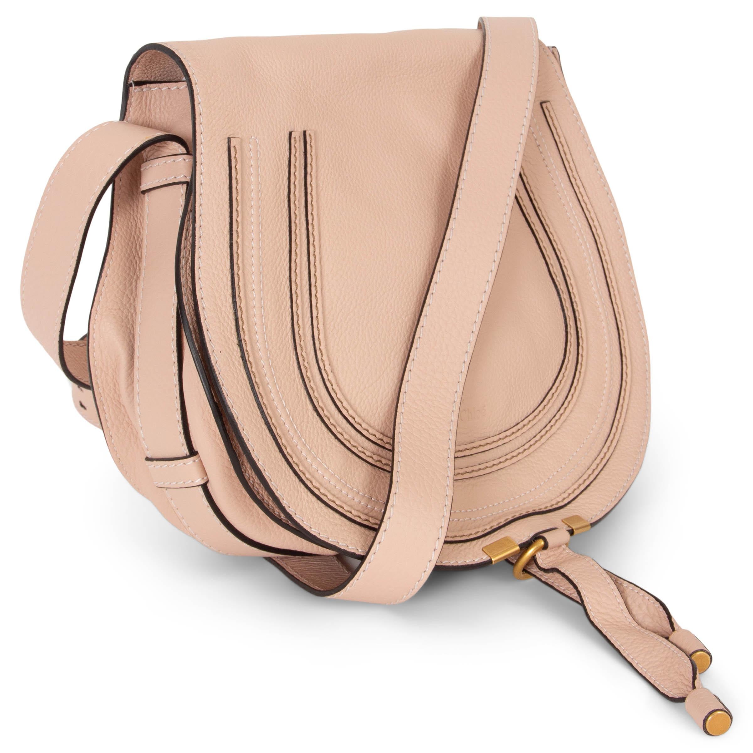 Questa borsa Chloé Marcie Medium Saddle Crossbody in pelle martellata Blush Nude (rosa pallido), autentica al 100%, è un accessorio chic e versatile. Caratterizzata da una silhouette arrotondata con una linea pulita, è impreziosita dalle iconiche