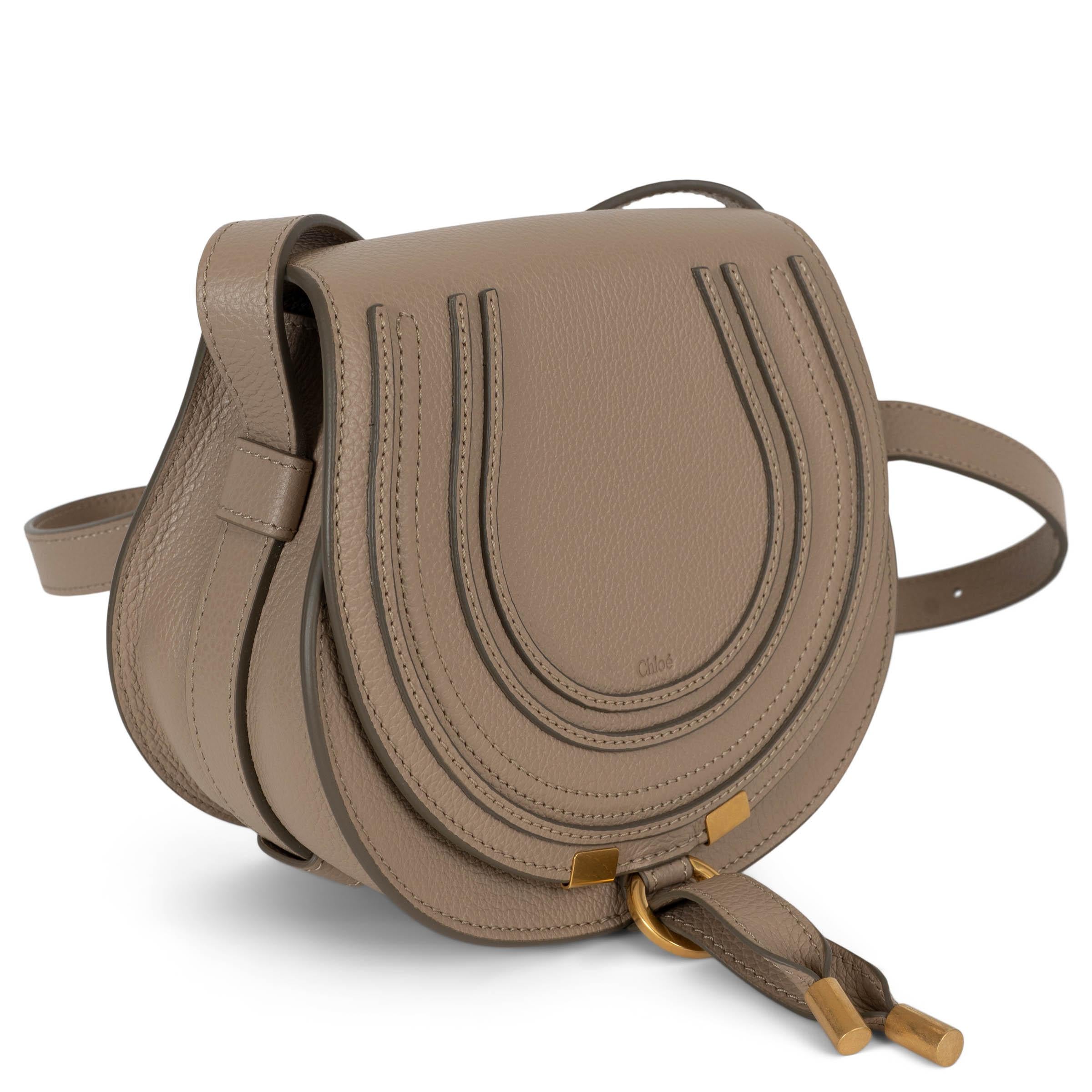 Questa borsa Chloé Marcie Small, autentica al 100%, è realizzata in pelle granulata Boyish Brown (beige sabbia), che riflette il caratteristico mix di chic parigino e fascino bohémien della Maison. Presenta una tracolla regolabile, finiture dorate e