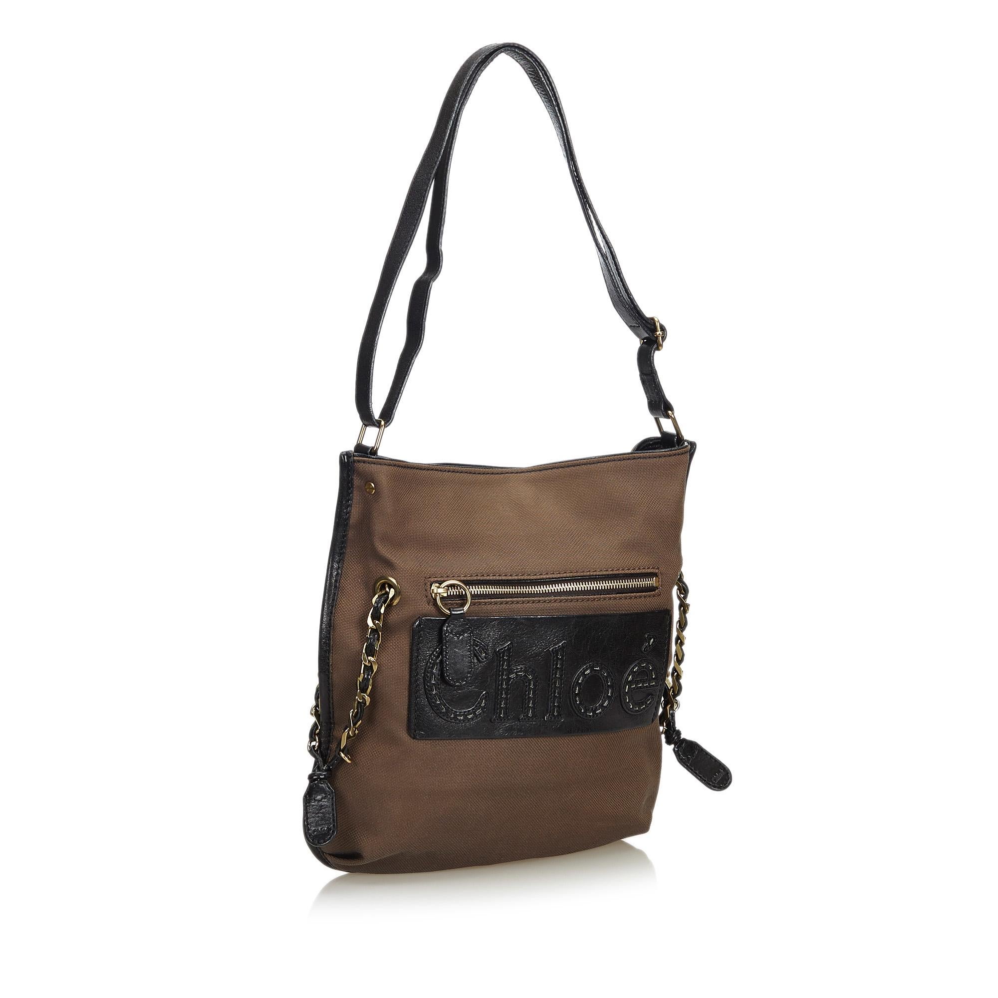 This shoulder bag features a canvas body with leather trim, a flat leather strap, a top magnetic closure, and an interior slip pocket. It carries as AB condition rating.

Inclusions: 
Dust Bag

Dimensions:
Length: 36.00 cm
Width: 35.00 cm
Depth: