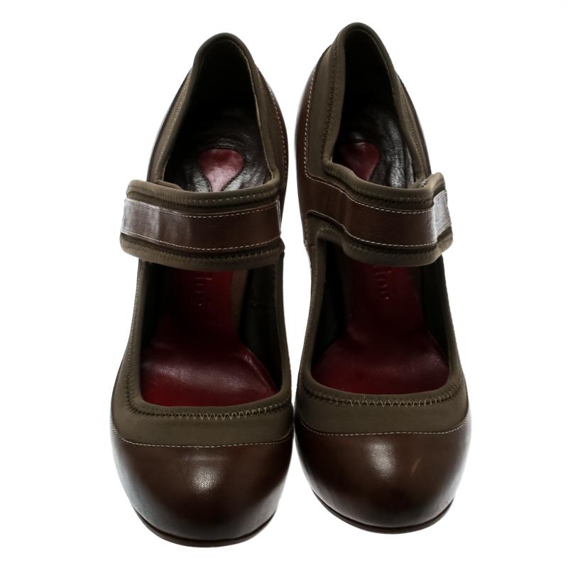 With such a chic pair as these Chloe Mary Jane pumps, you are sure to make a statement! These brown pumps have been crafted from leather and khaki fabric and feature round toes. They have been styled with a strap detailed across the vamps and come