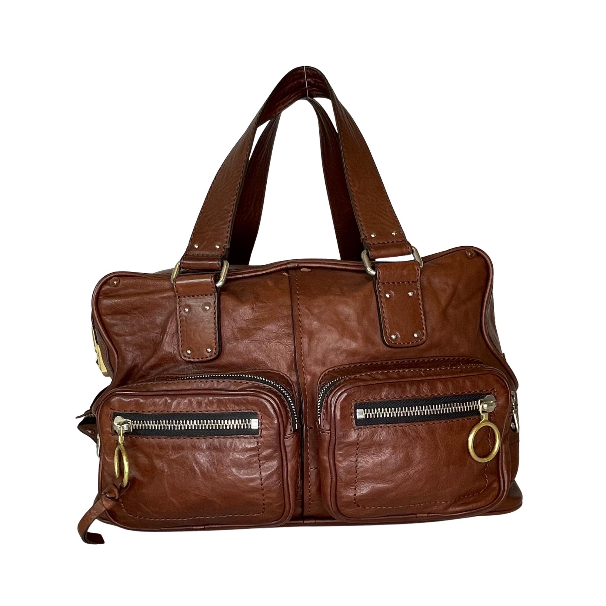 The Betty bag features a leather body, front and back exterior zip pockets, top zip closure, interior zip pockets, and a leather coin case attached to the top of the bag.

COLOR: Brown
MATERIAL: Calf leather
ITEM CODE: 01 - 06 - 53
MEASURES: L 16” x