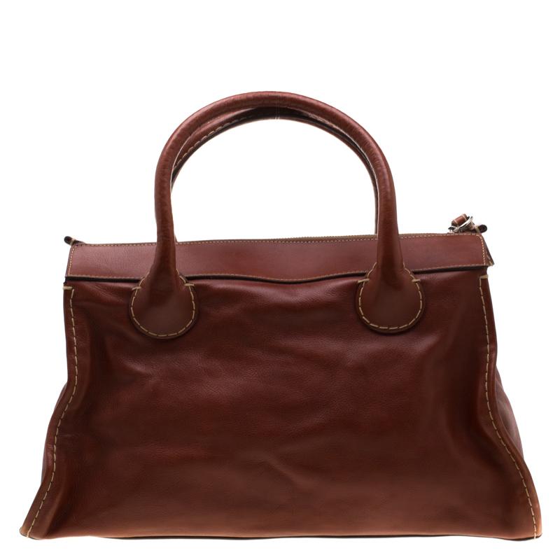 Upgrade your accessories collection with this gorgeous leather handbag. This polished bag has a canvas lined interior, two handles and a front pocket. This delightful bag from Chloe is all that you need to instantly amp your look. This brown bag is