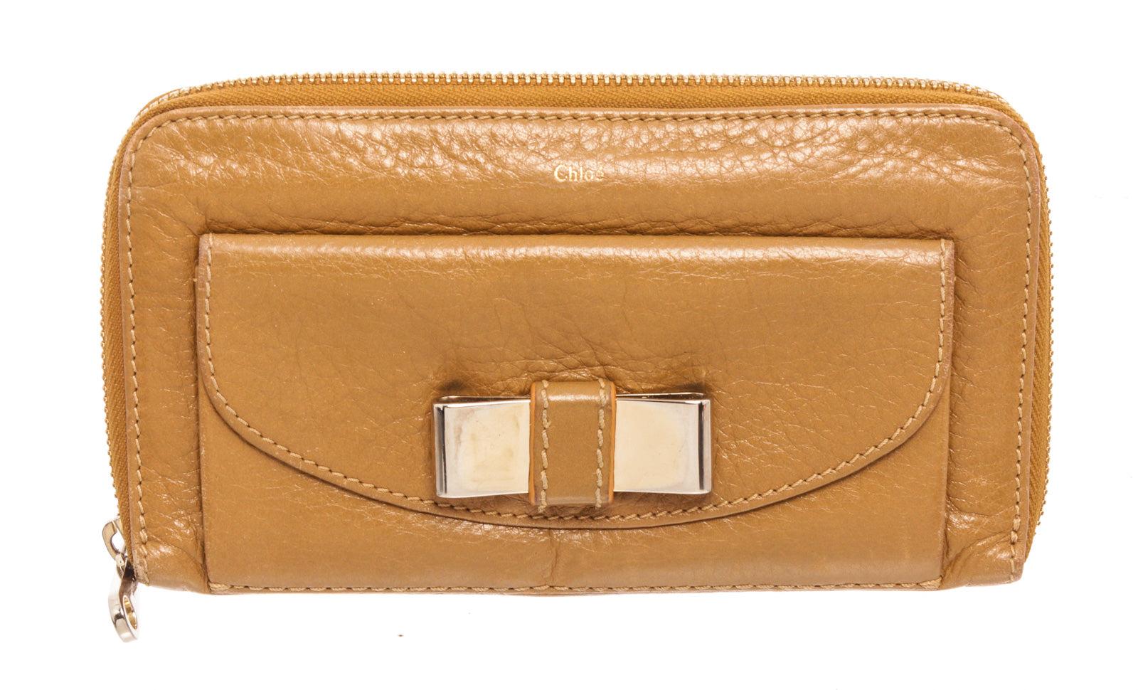 Chloe Brown Leather Lily Zip Wallet with gold-tone hardware, single exterior flap pocket, three interior compartments; one with zip closure, tonal leather and grosgrain lining, dual bill compartments, eight card slots and zip-around closure.
33175MSC