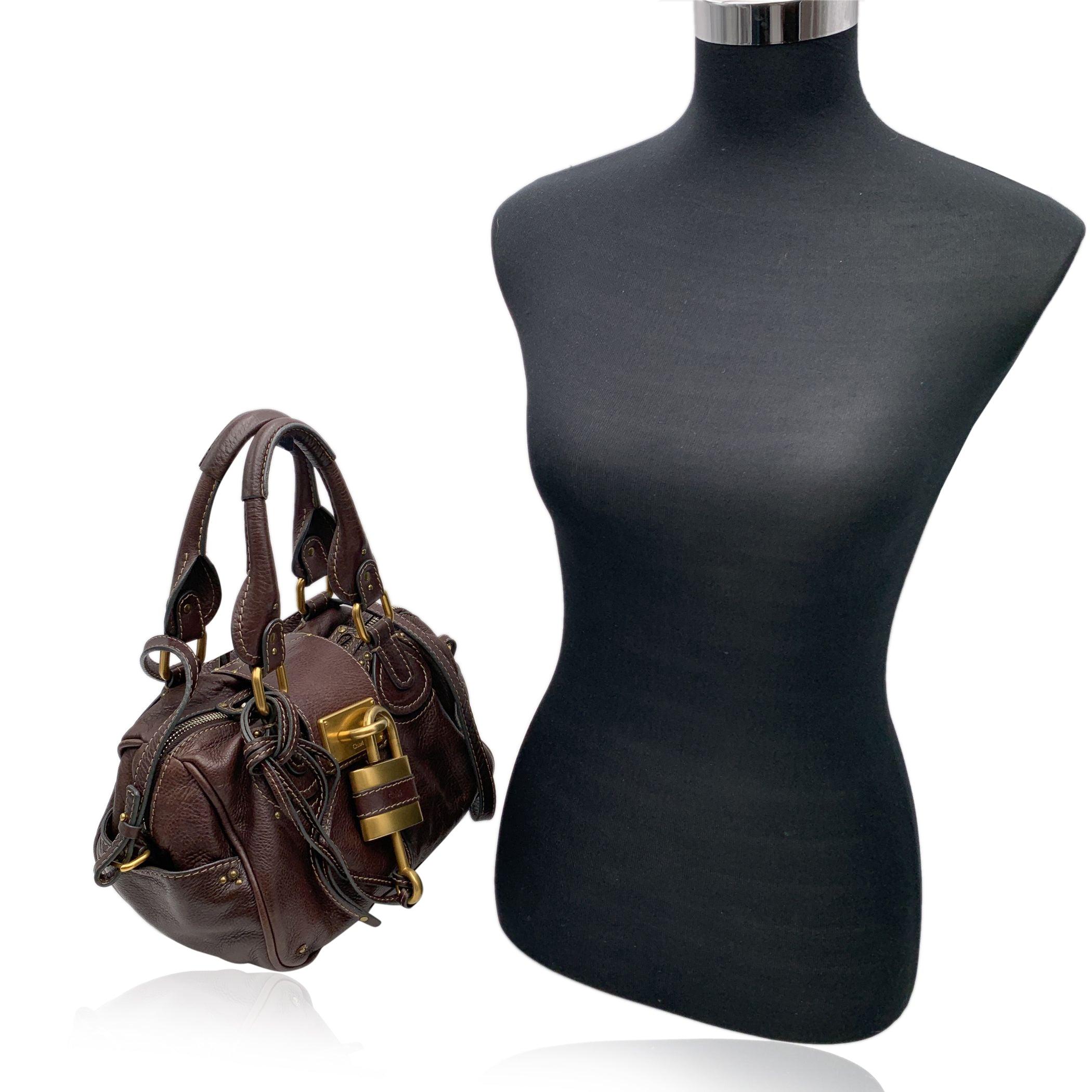 Magnifique sac 'Paddington' de CHLOE en cuir véritable de couleur marron. Ce sac présente des détails intenses tels que des ferrures épaisses, des ceintures ainsi que deux poignées en cuir roulées. Sur le dessus du sac se trouve le PADLOCK classique
