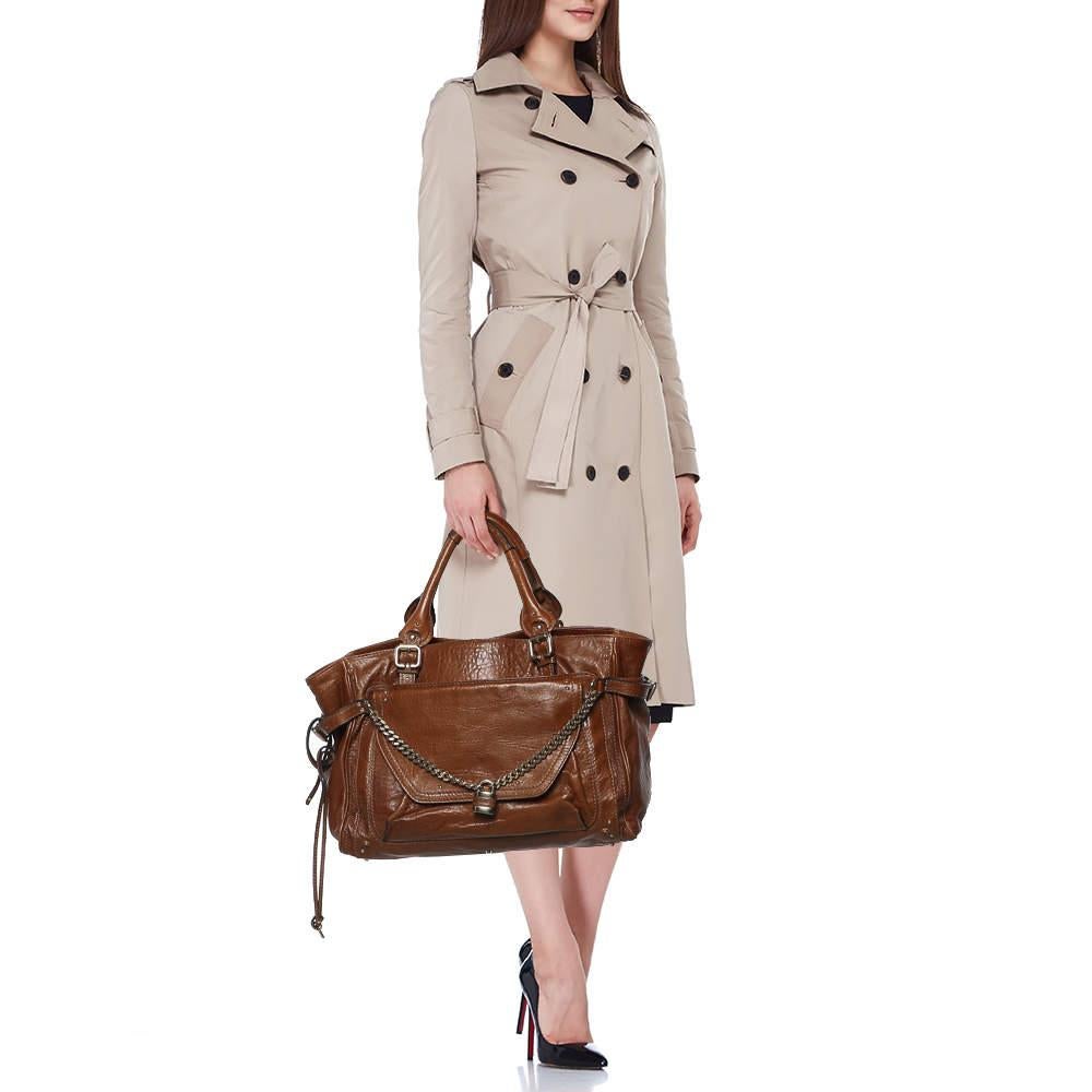 Made from brown leather, this Chloe Paddington tote strikes the perfect balance between fashion and function. The lock design on the front pocket gives it a distinct touch while the dual handles make it easy to carry. Lined with fabric, the spacious