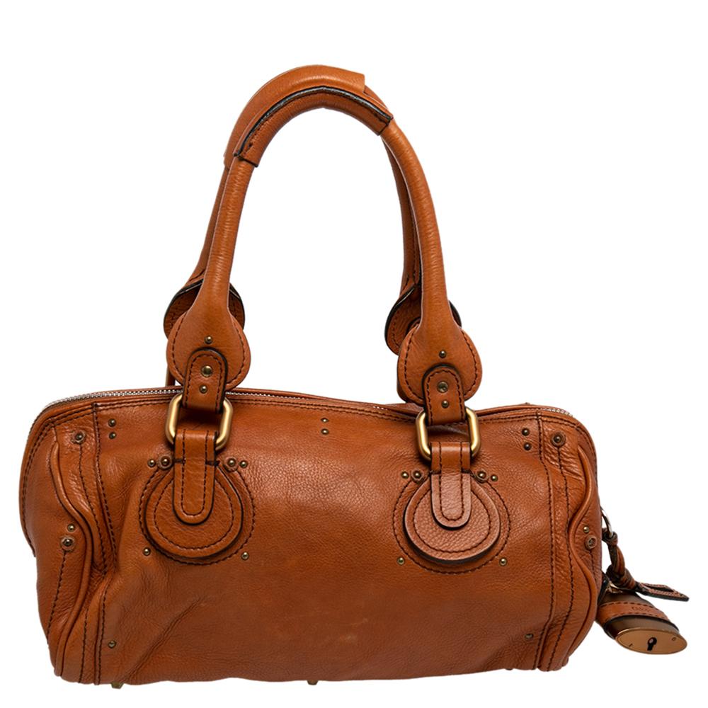 Este bolso Chloé Paddington está hecho para asistir a tu estilo impecable en todos los días. Los herrajes dorados con un grueso cierre lateral atraen fácilmente todas las miradas. La piel tiene una textura interesante, mientras que el interior está
