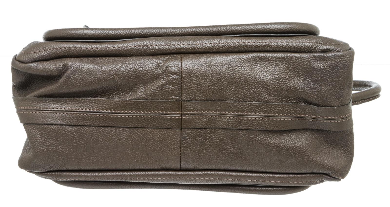 Crafted out of brown leather, dual flat handles, gold tone hardware, and zip top closure. Inner is brown fabric lined with one side zip pocket.

16239MSC MKR