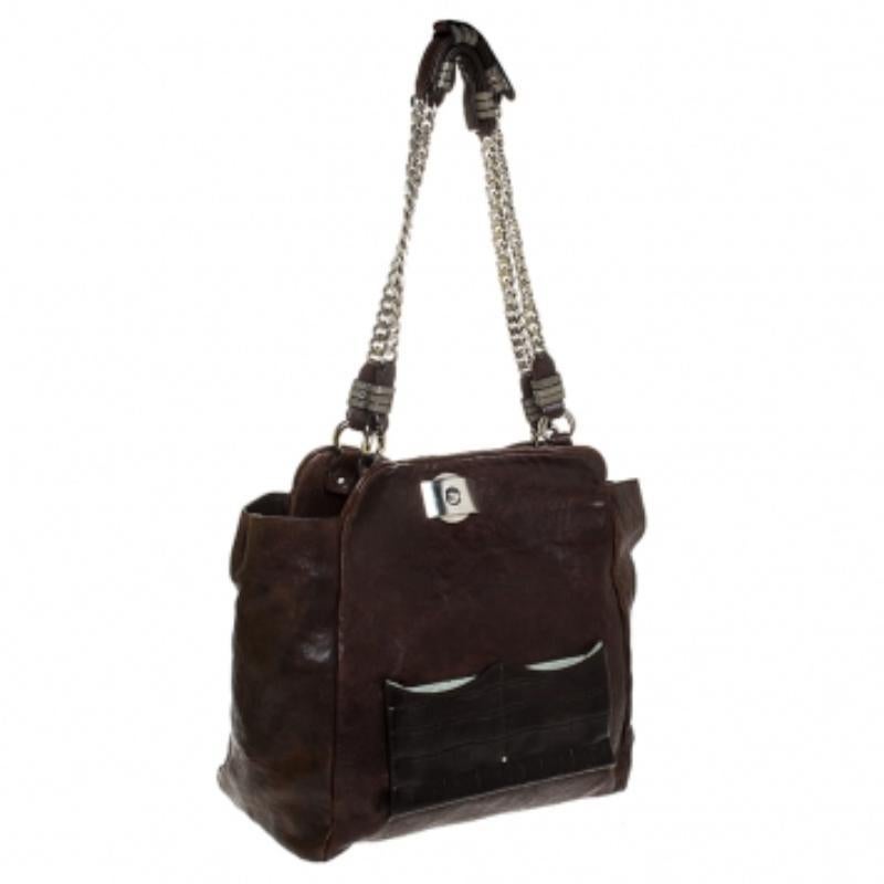 This Chloe tote will make a priceless addition to your closet. Crafted from brown leather, this vintage piece would go perfectly for any of your occasions. It has a lock closure that leads to a fabric lined interior and comes with two chain handles.
