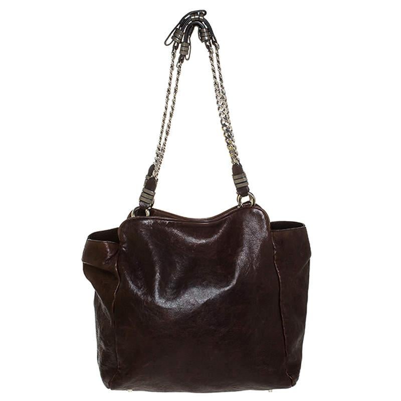 This Chloe tote will make a priceless addition to your closet. Crafted from brown leather, this vintage piece would go perfectly for any of your occasions. It has a lock closure that leads to a fabric lined interior and comes with two chain
