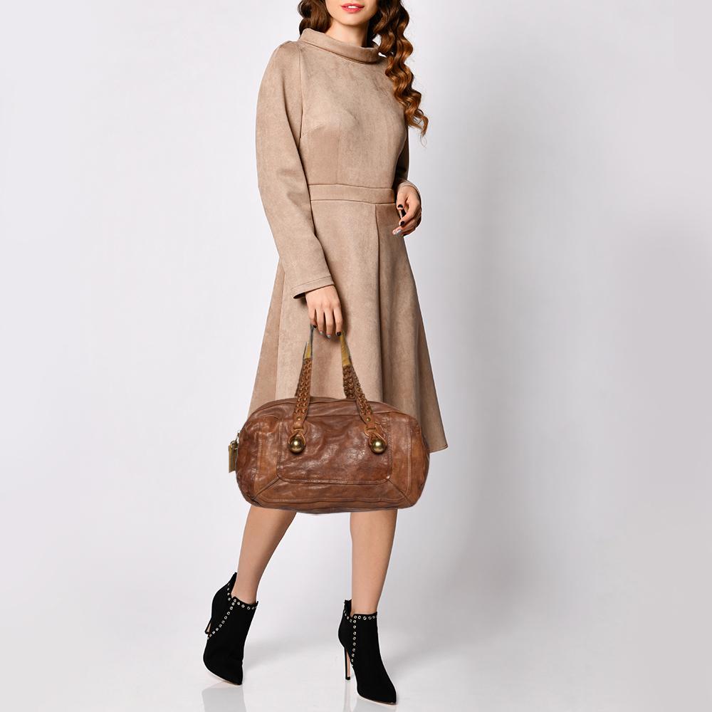 Carry your belongings in style and convenience with this shoulder bag from Chloe. The top zip reveals a canvas-lined interior that is capable of storing your items in a safe and secured way. Brown leather is used to craft the exterior of this chic