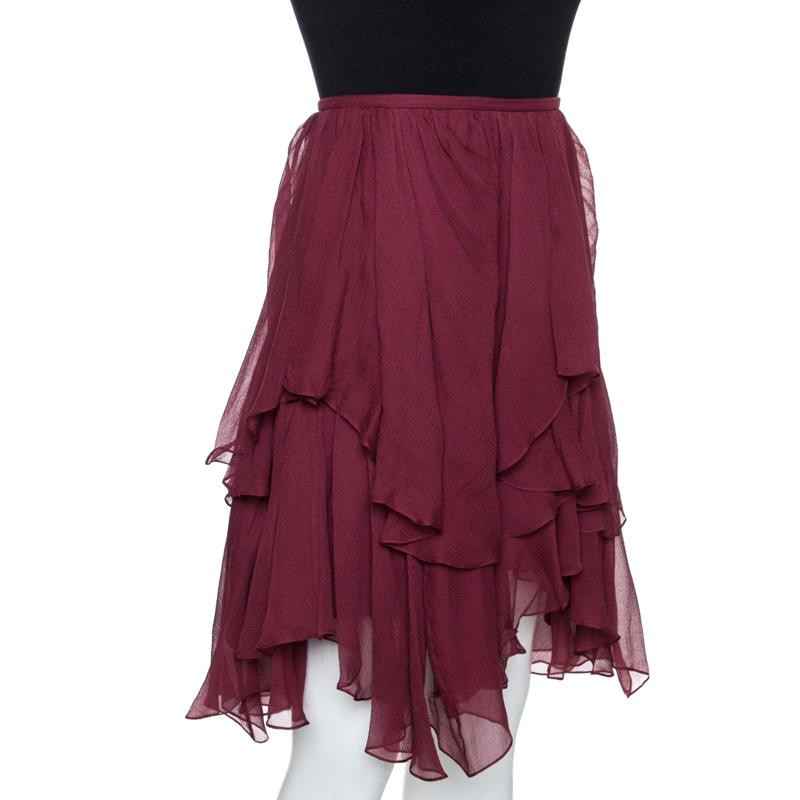 This stylish skirt comes from the house of Chloe. Crafted from 100% silk, it flaunts a lovely shade of burgundy. It has a lovely silhouette and is styled with asymmetrical layers too add interest and movement. This mini skirt is equipped with a zip