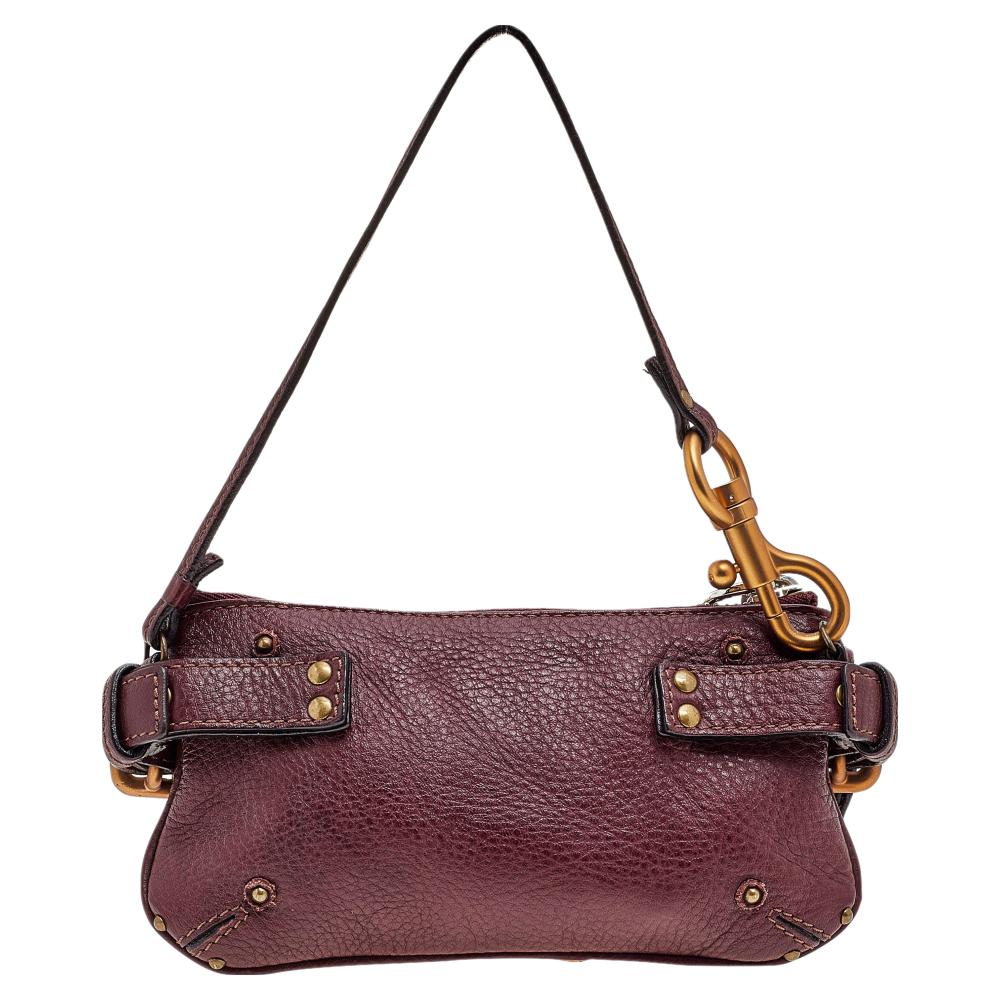 This Chloe Paddington clutch is built to assist your impeccable style on all days. Gold-tone hardware with a chunky lock to the front easily attracts all the attention. The burgundy leather clutch is complete with a single handle.

Includes: Padlock