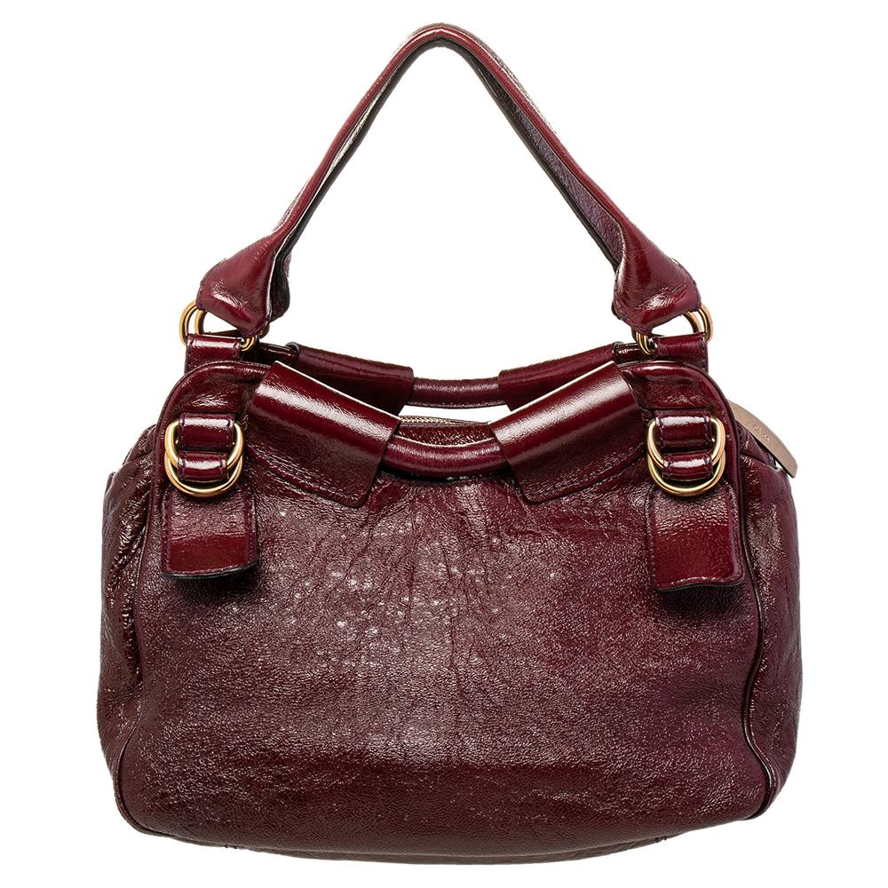 This burgundy patent leather bag is fabulously built and extremely alluring. An epitome of fashion, this beautifully crafted bag comes with a highly durable fabric interior. Complement the diva in you by adorning this attractive satchel from Chloe.

