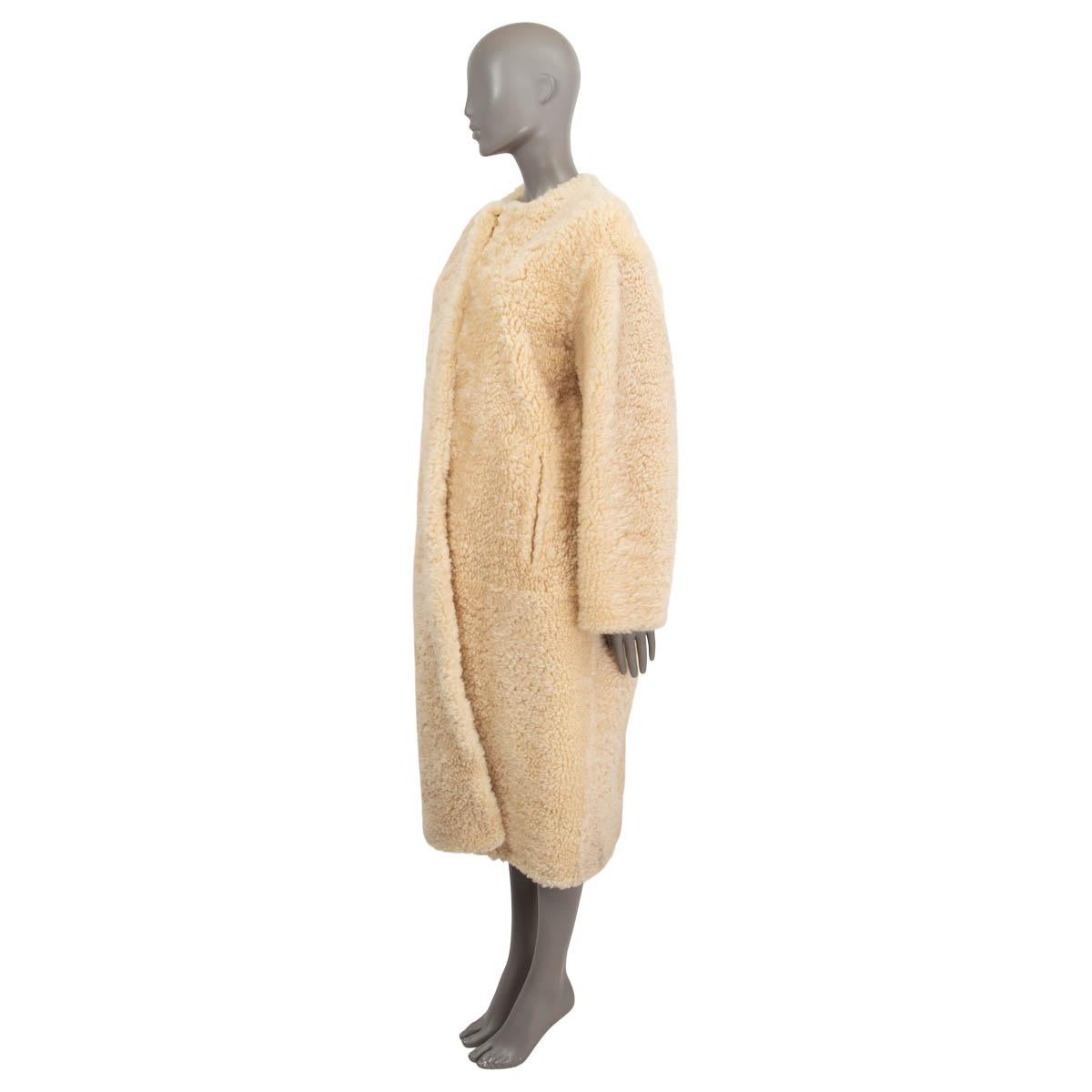 100% authentic Chloé collarless cocoon coat in butterceam (beige) shearling. Features a round neck and side slit pockets. Closes with concealed hooks. Lined in silk (100%). Has been worn and is in excellent condition.

2021 Fall/Winter by Gabriela