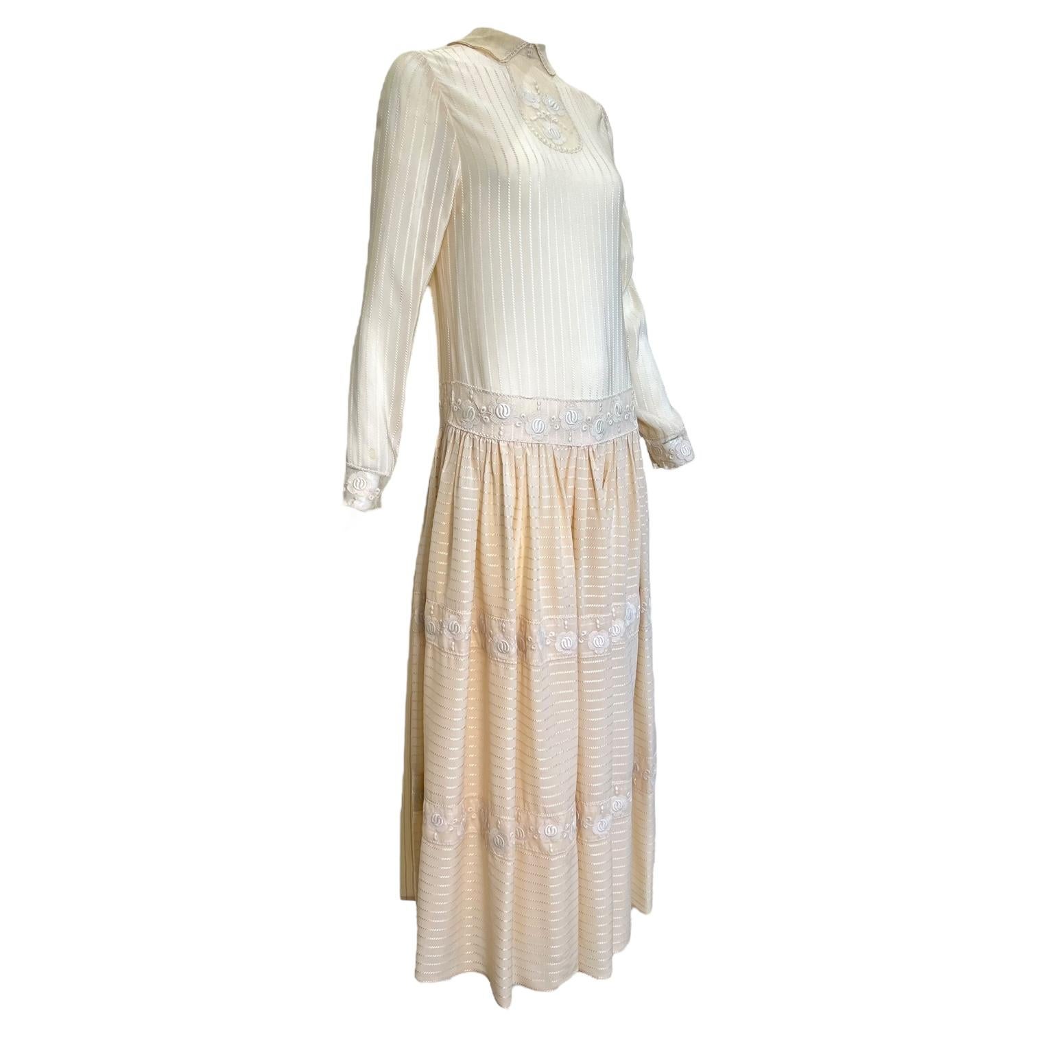 Un precioso vestido Chloé de los años 70 de la época que definió el reinado de Karl Lagerfeld. Este dulce vestido de seda está detallado con delicadas inspiraciones de principios de los años 20, como la silueta de cintura caída, la yema bordada, el