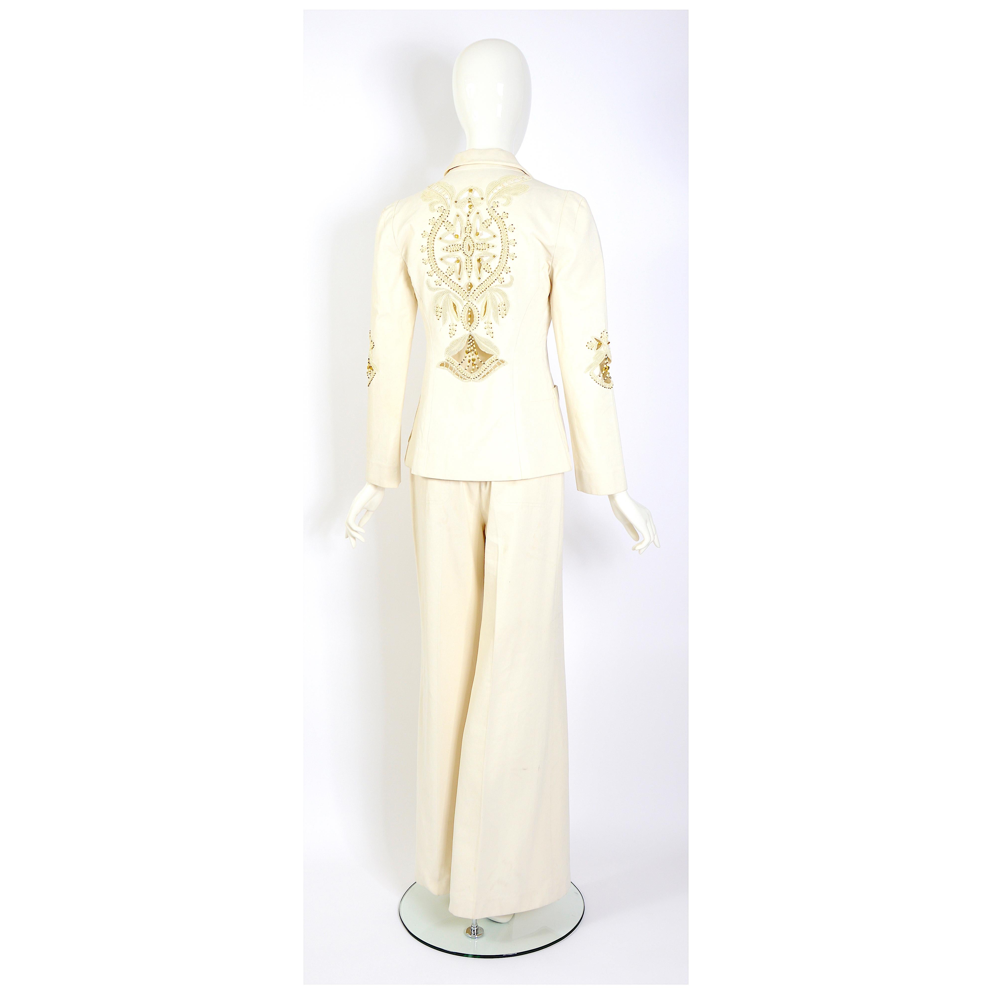 Zeitlose Eleganz mit diesem umwerfenden Vintage-Kostüm von Chloé by Phoebe Philo aus dem Frühjahr/Sommer 2002. Der schicke cremefarbene Anzug ist am Rücken und an den Ärmeln mit edlen Perlen und charmanten Herzen verziert.
Verpassen Sie nicht die