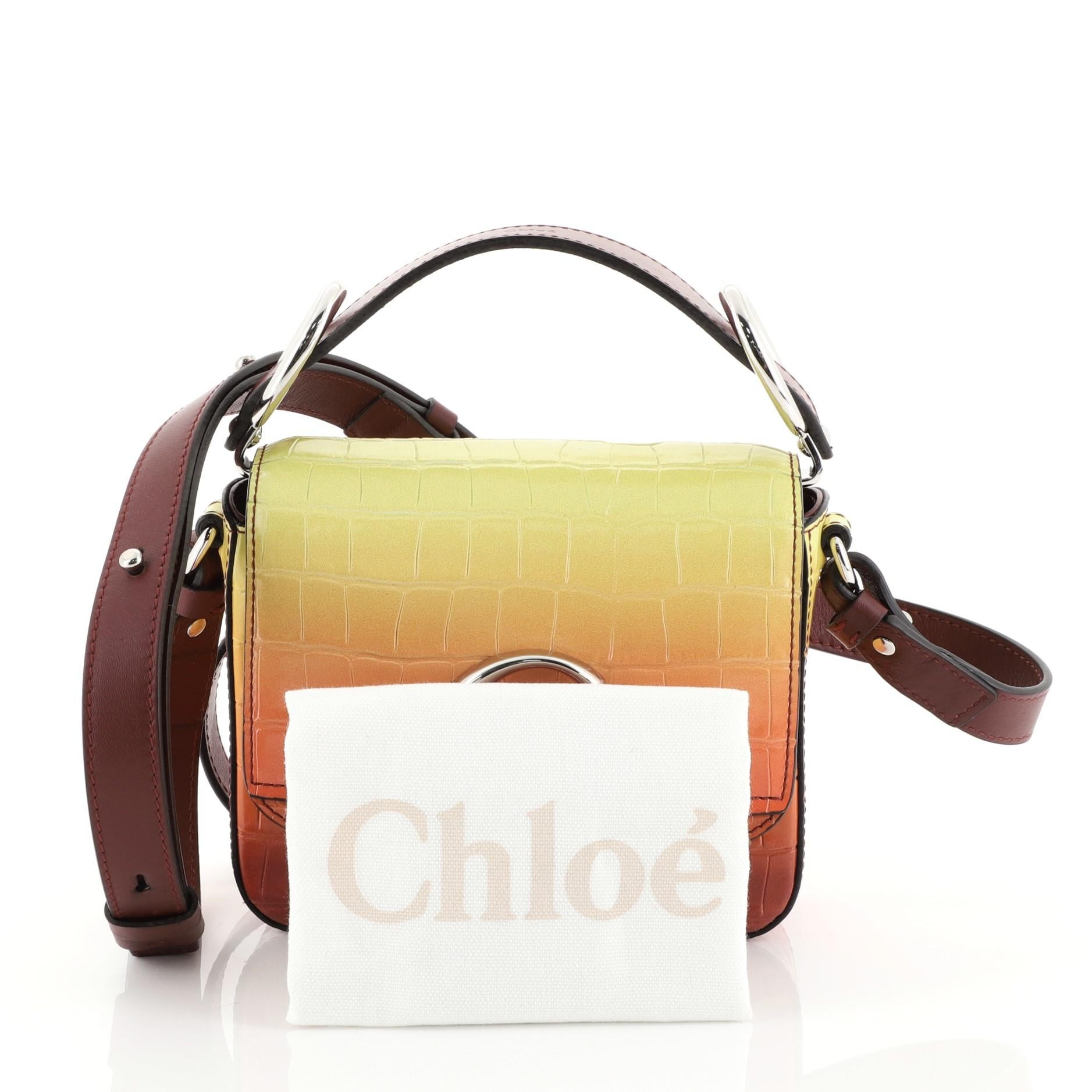 This Chloe C Crossbody Bag Ombre Crocodile Embossed Leather Mini, crafted in multicolor ombre crocodile embossed leather, features an adjustable leather strap, C logo on flap, and silver-tone hardware. Its push-lock closure opens to a neutral fabric