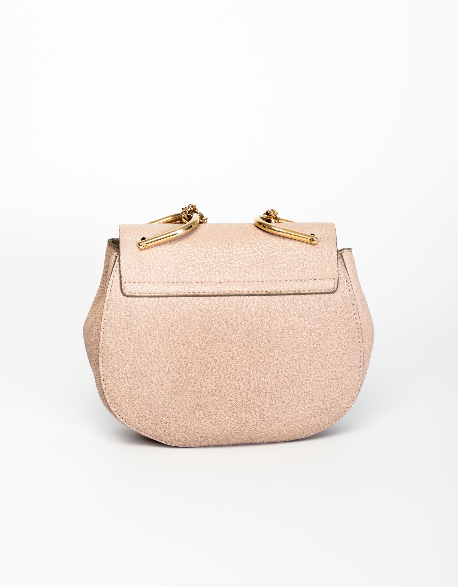 Chloé's iconic drew bag is made of pebbled cement pink leather & features a round body, fold-over top, gold-tone hardware, long elegant chain shoulder strap with a suede lined interior and an internal slip pocket.

COLOR: Cement pink
MATERIAL: Grain