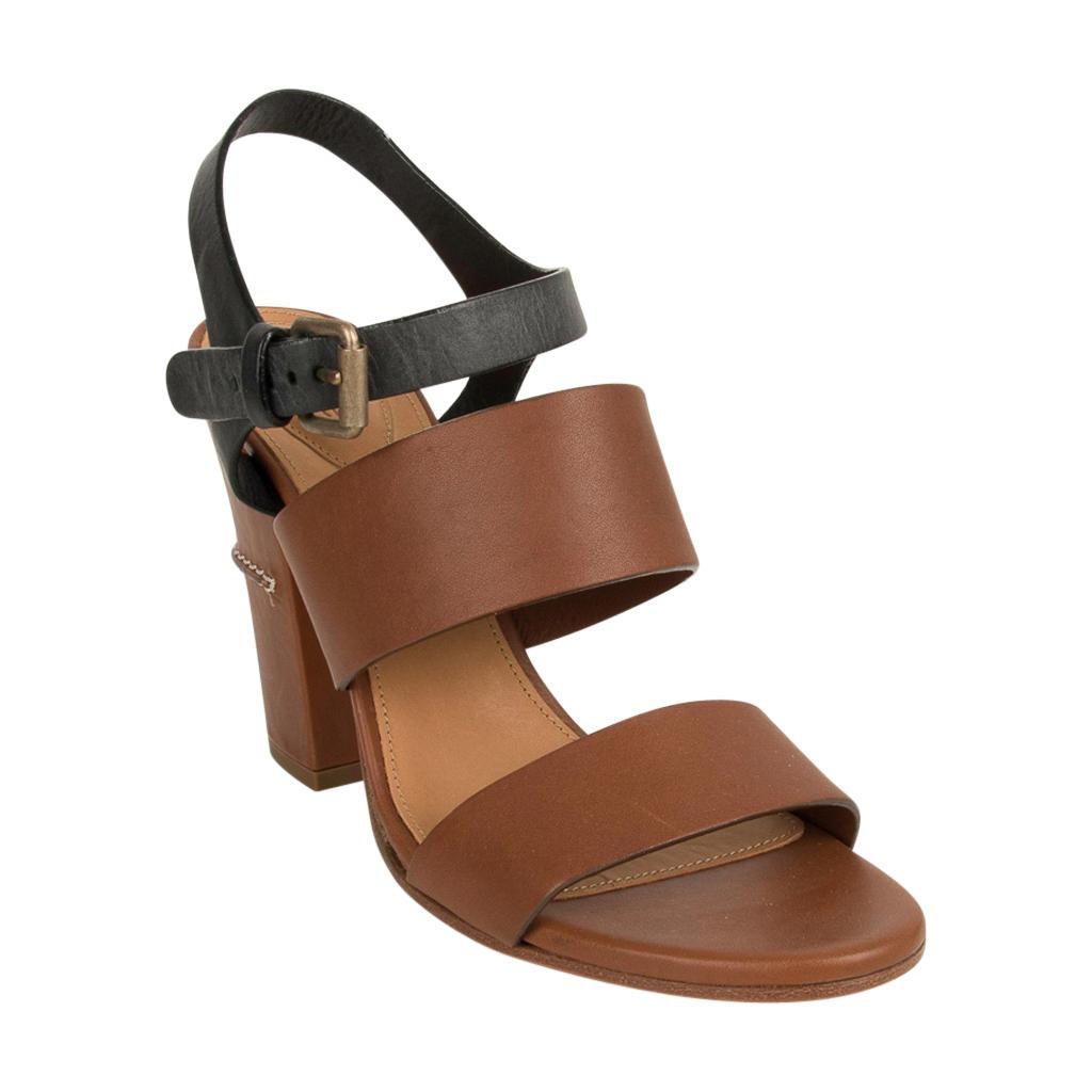Chloe brown and black block heel sandal.
Bold brown straps across toes and top of foot.
Black ankle strap.
Block heel is covered in brown leather and has decorative stitching around mid-heel.
NEW or NEVER WORN.
Final Sale

SIZE 39
USA SIZE 9

SHOE