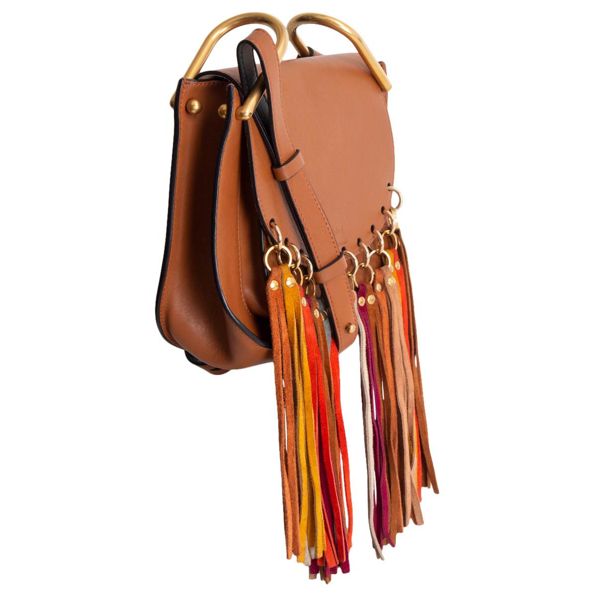 100% authentic Chloé Fringe Hudson Small Shoulder Bag in coganc brown calfskin embellished with multicolor fringes and gold-tone metal rings. Opens with a magnetic button under the flap to a beige suede interior with one open pocket against the back