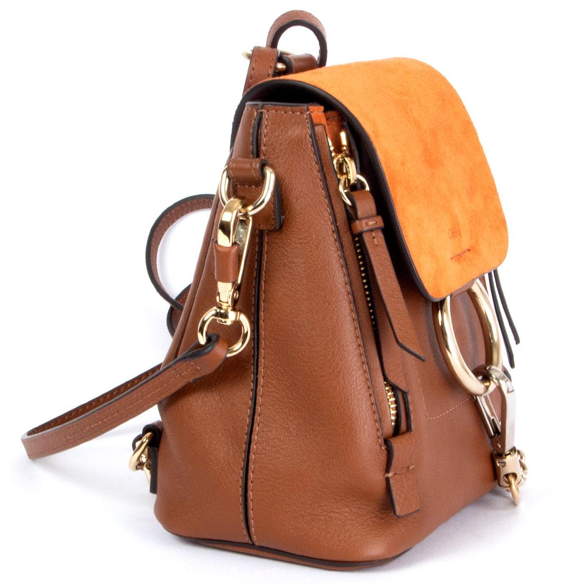 100% authentic Chloé 'Mini Faye' backpack in cognac calfskin and orange suede featuring light gold-tone and silver-tone. Double leather backpack straps and detachable leather strap. Opens with a flap top with magnetic snap closure. Lined in cream