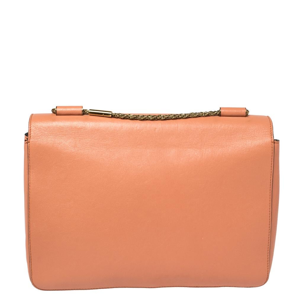 Every curve and detail on this Chloe Elsie is grand which adds to its worth. It has been crafted from coral orange leather, adorned with gold-tone hardware, and styled with a front flap. The bag is secured by a twist-lock revealing a well-sized