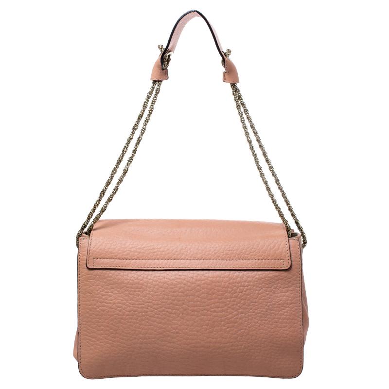 Gorgeous is the word for this Sally bag from Chloe! The coral orange bag has been crafted from leather and styled with a front flap that features a gold-tone flip-lock. It flaunts a chain and leather shoulder strap and comes equipped with protective