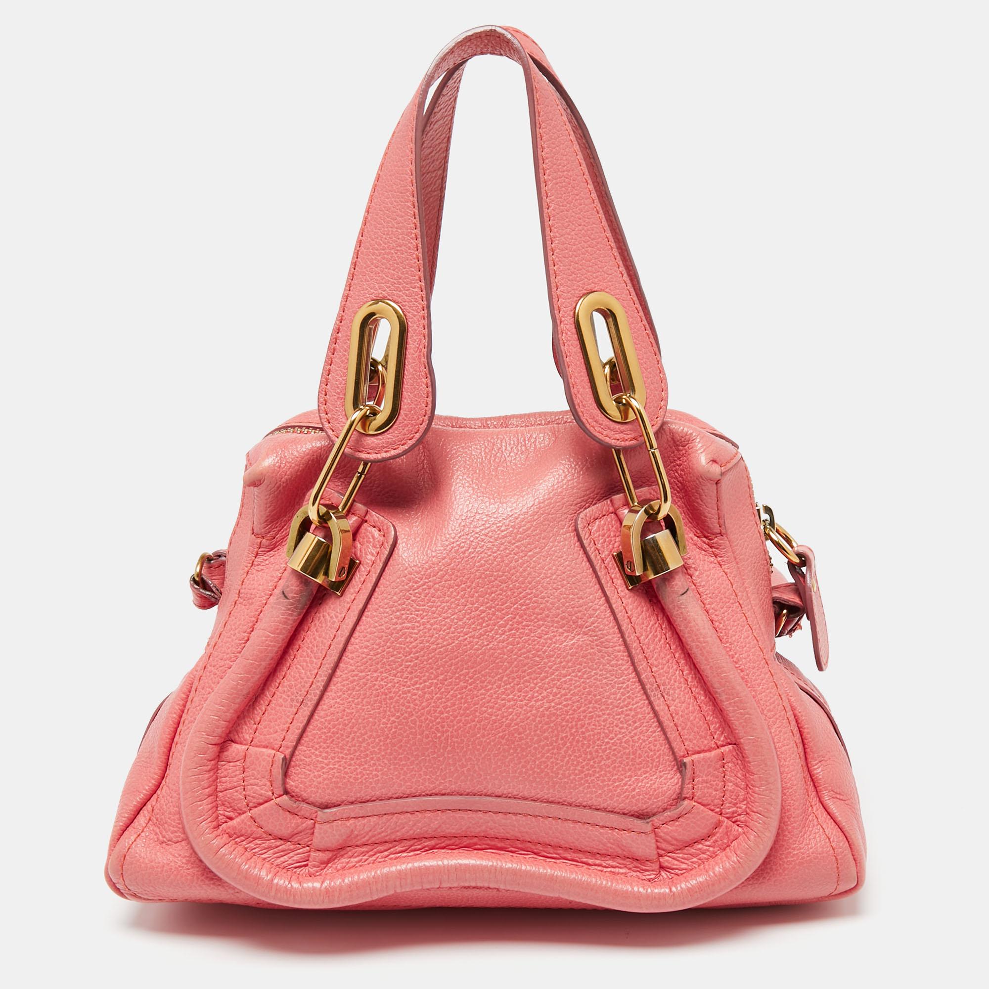 As one of Chloé's most loved bags, the Paraty does make a fine addition to any closet. This here is crafted from leather and gold-tone hardware. The coral pink bag has two handles, a shoulder strap, and a spacious fabric-lined interior to hold all