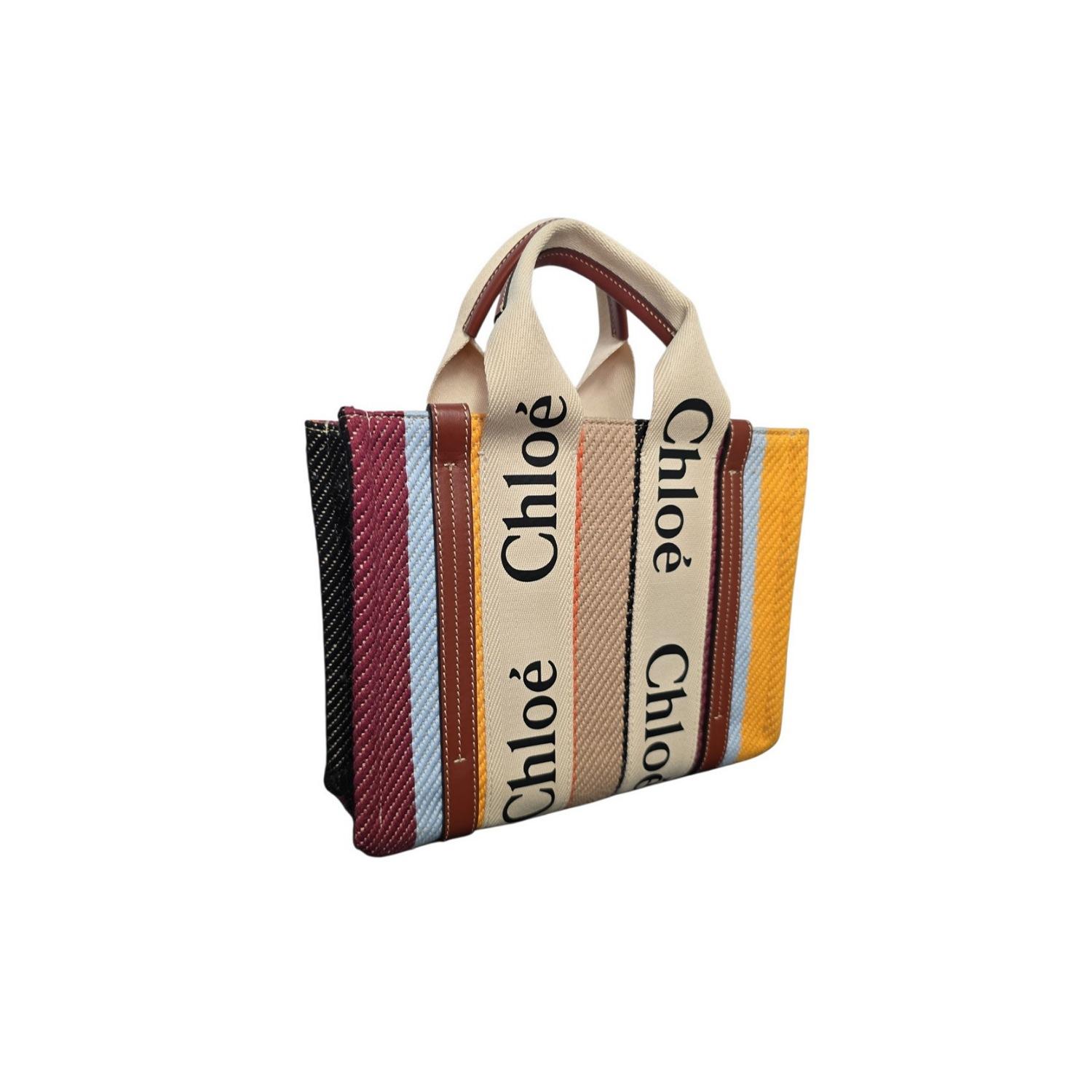 Le petit fourre-tout à ruban rayé en coton et cuir de Chloé associe des fibres de coton mélangées durables à des garnitures en cuir raffinées pour un look d'une élégance unique. Ses dimensions compactes de 10