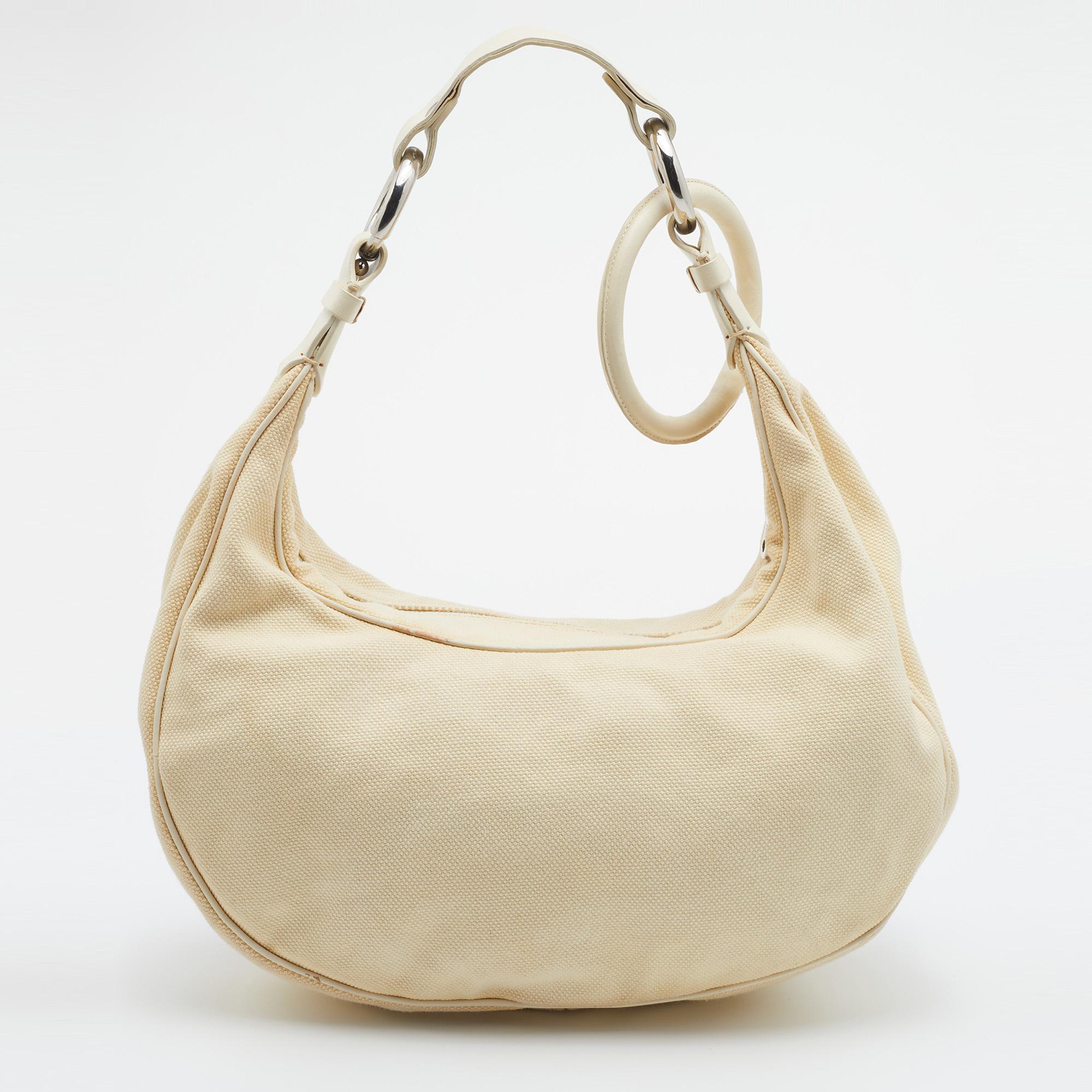 Feminine and classy, this Chloe hobo is made from canvas and leather. Featuring a single handle and a zip closure to secure the fabric-lined interior, this pretty bag is the right choice for your daily essentials. Turn heads with it!
