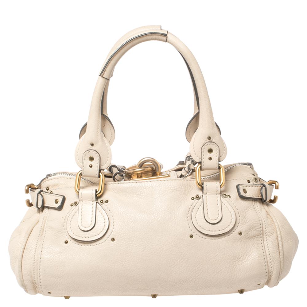 This Chloé Paddington satchel is built to assist your impeccable style on all days. Gold-tone hardware with a chunky lock acts as the highlight of this iconic creation. The exterior is in cream leather while the interior is in canvas & leather and
