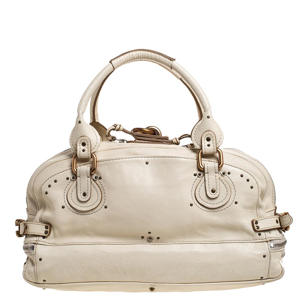 This Chloe Paddington satchel is built to assist your impeccable style on all days. Gold-tone hardware with a chunky lock on the front easily attracts all the attention. The cream Leather has a textured finish while the fabric interior is sized to