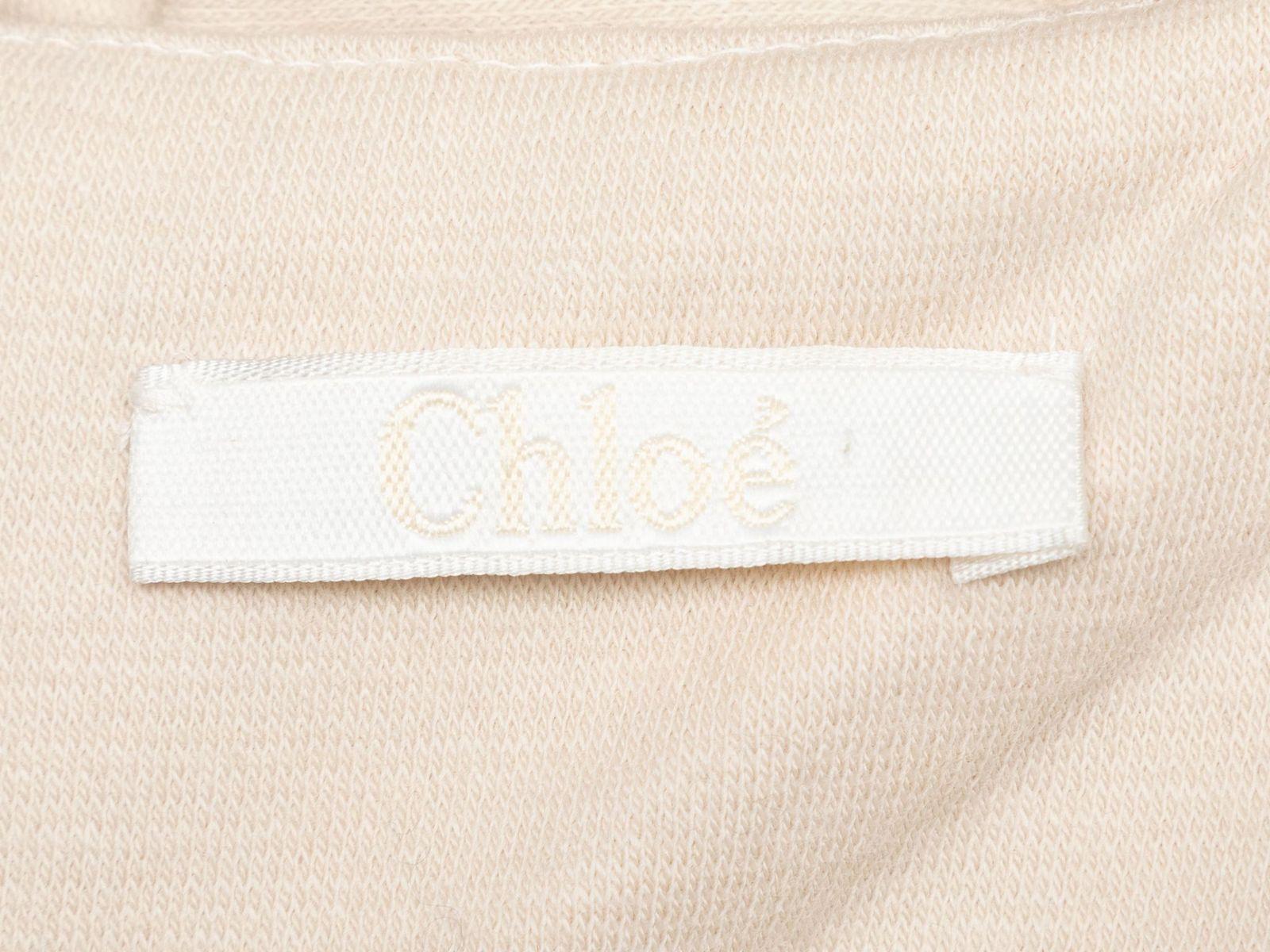 Product Details: Cream virgin wool eyelet-trimmed dress by Chloe. Short sleeves. Bateau neckline. Zip closure at center back. 32