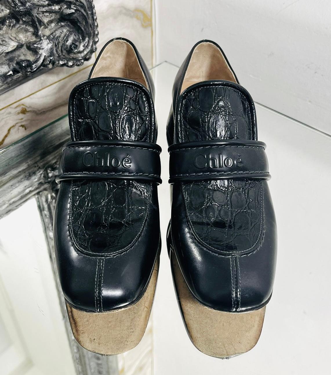 Chloe Croc Embossed Logo Leather Loafers

Black 'Cheryl' loafers designed with 'Chloe' logo embossed on the vamp straps.

Detailed with round moc toe and croc detailing to the padded tongue and short, block heel.

Featuring beige suede lining and