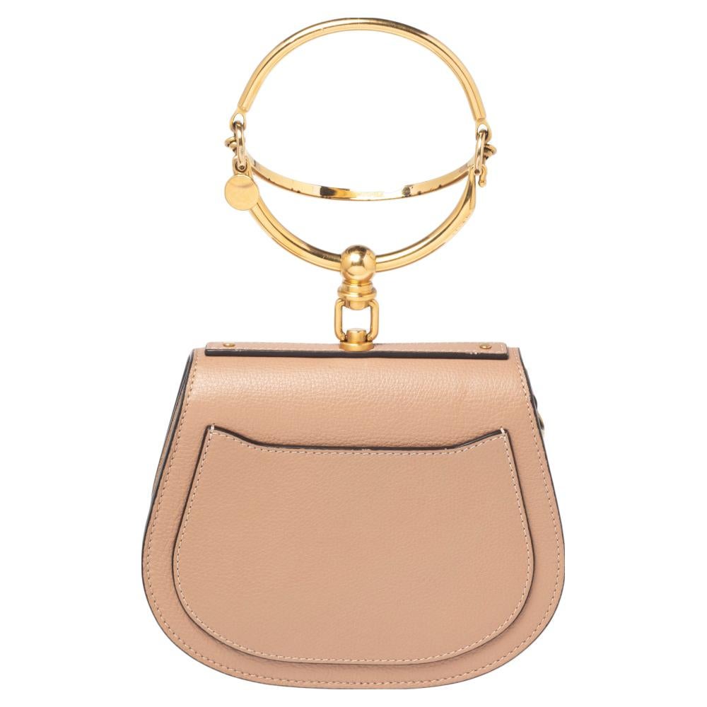 This Nile bag by Chloe can become your most favorite bag, thanks to its unique shape and the bracelet handle. It has been crafted from dark beige leather as well as suede and styled with a front flap that opens to a suede interior housing an open