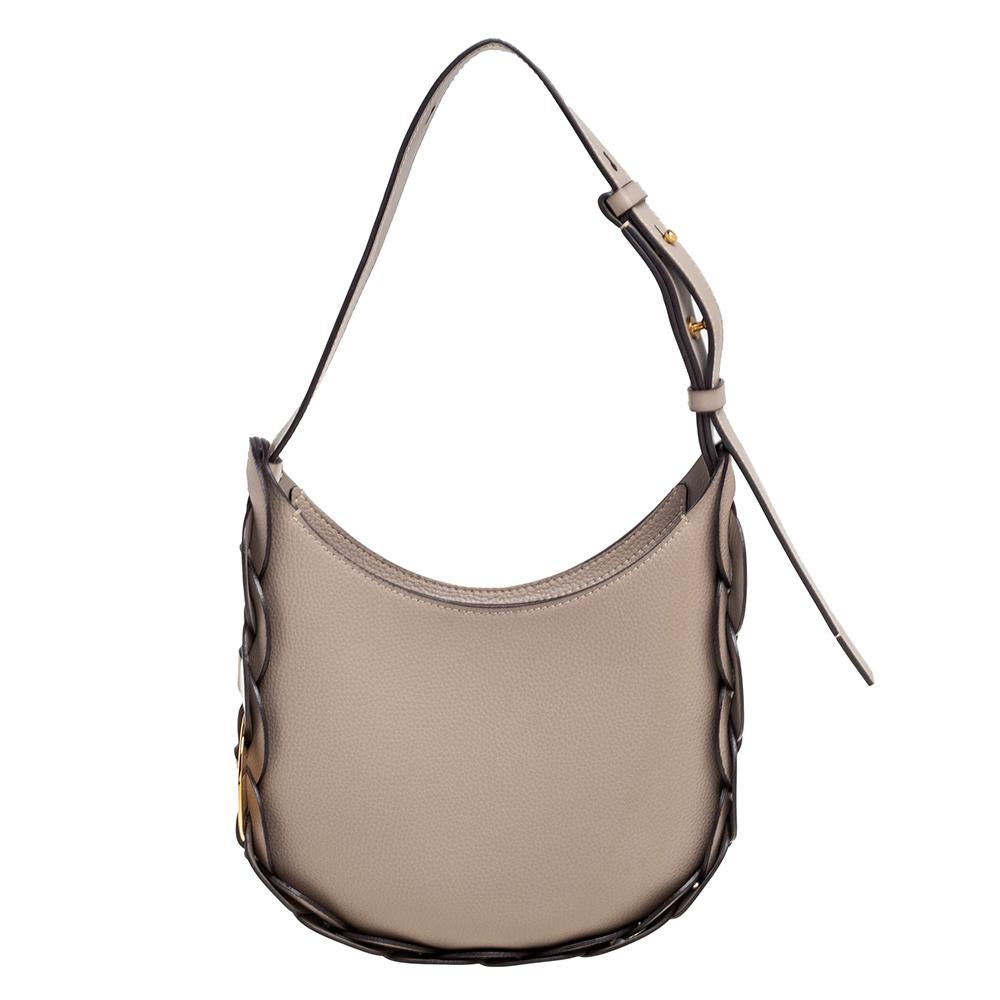 Incorporate a sense of charm and feminine aesthetic into your accessories by adding this Darryl hobo from the House of Chloe. It is made from dark-beige leather and embellished with gold-toned hardware. This hobo has a single handle drop and a