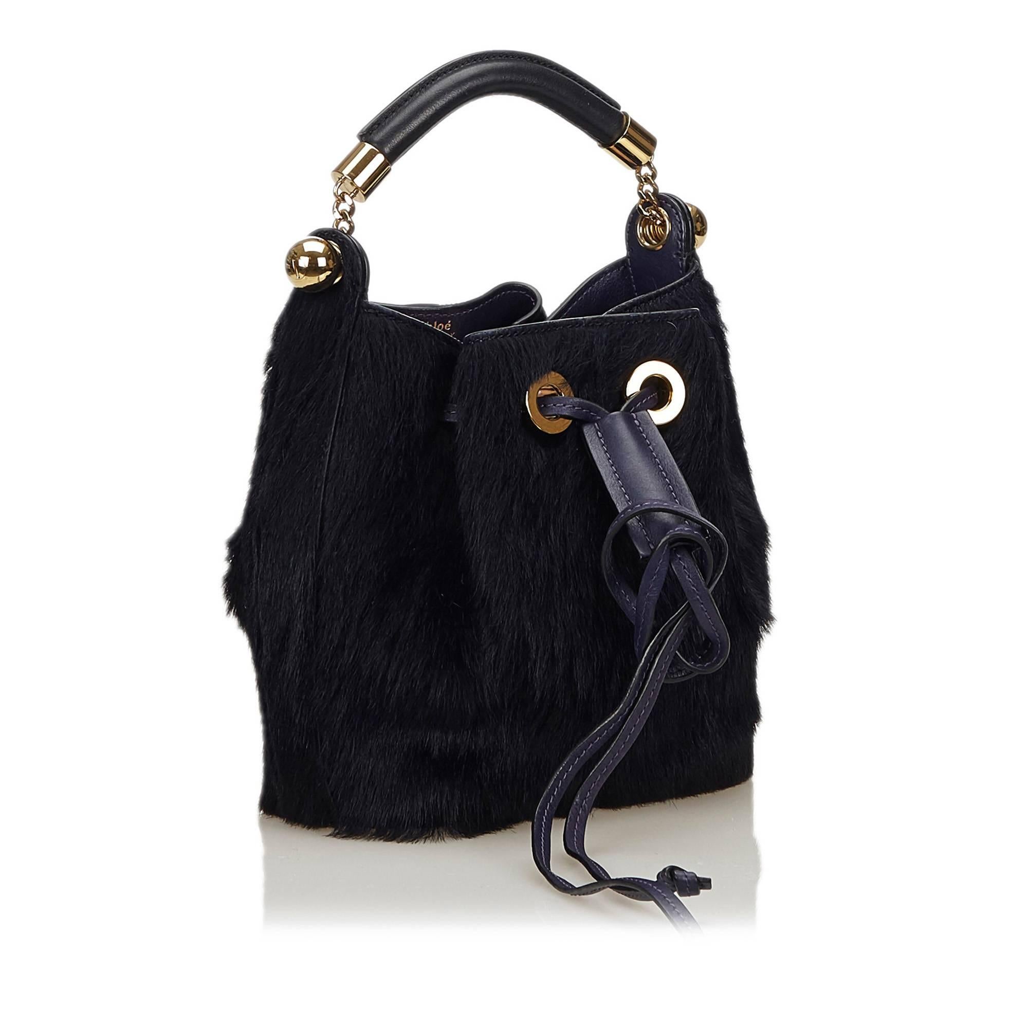 The Gala Bag features fur body, rolled leather handle, and a top drawstring closure. 

It carries an A condition rating.

Dimensions: 
Length 18 cm
Width 18 cm
Depth 8 cm
Hand Drop 8 cm

Inclusions: Shoulder Strap

Color: Blue x Dark Blue

Material: