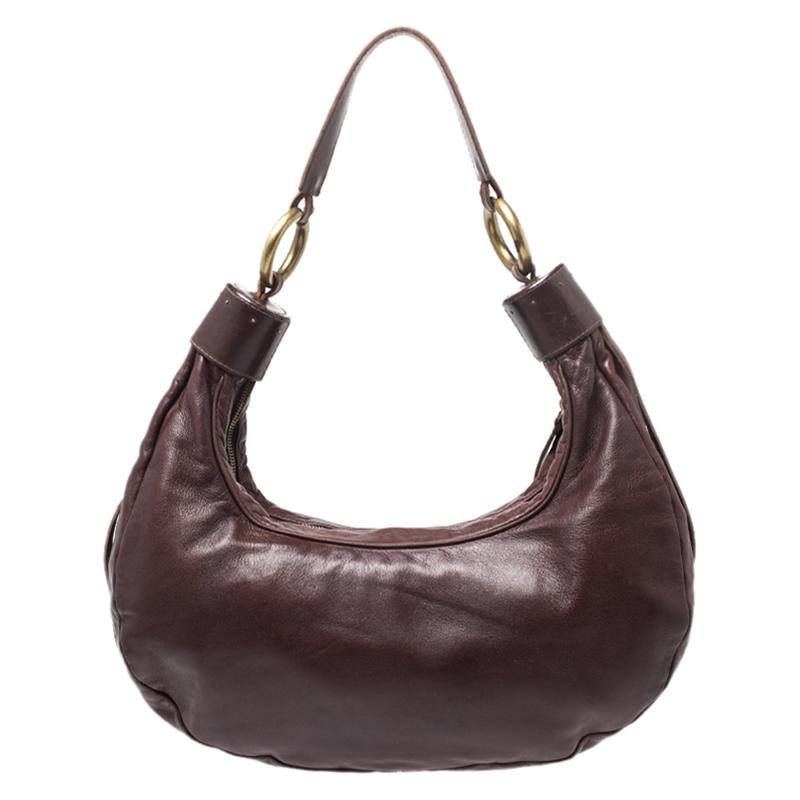 This Chloe design has a dark brown leather exterior and gold-tone hardware. The hobo carries a crescent shape and features a top-zip closure that opens to a fabric-lined interior with the brand's label. Raise your style quotient by flaunting it with