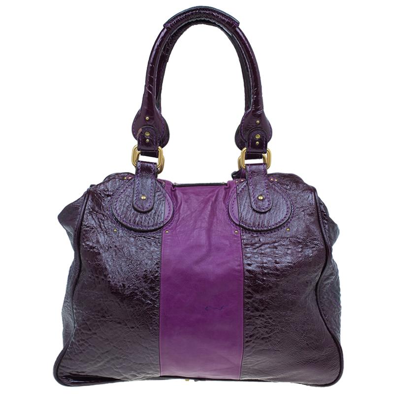 Make an everyday look even more intriguing with this Purple Paddington Tote from the French label, Chloe. This tote is made from textured leather in dark purple with a smooth contrasting leather panel in the middle. The look is finished with a large