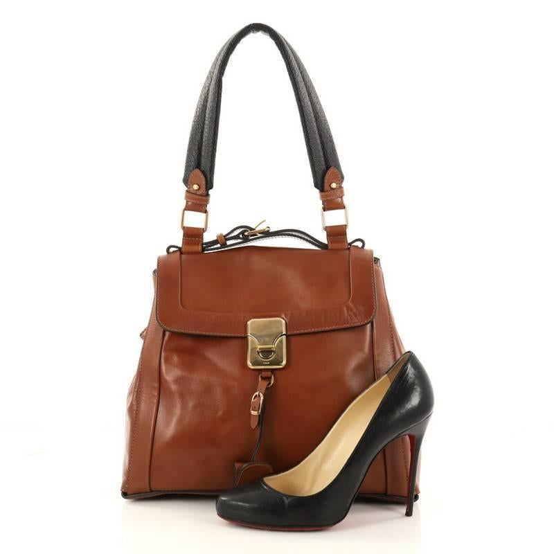 This authentic Chloe Darla Satchel Leather Medium is a bag with a retro appeal and modern touches. Crafted in brown leather, this bag features a flat leather top handle, leather shoulder strap, sides zip that open to expand, protective base studs