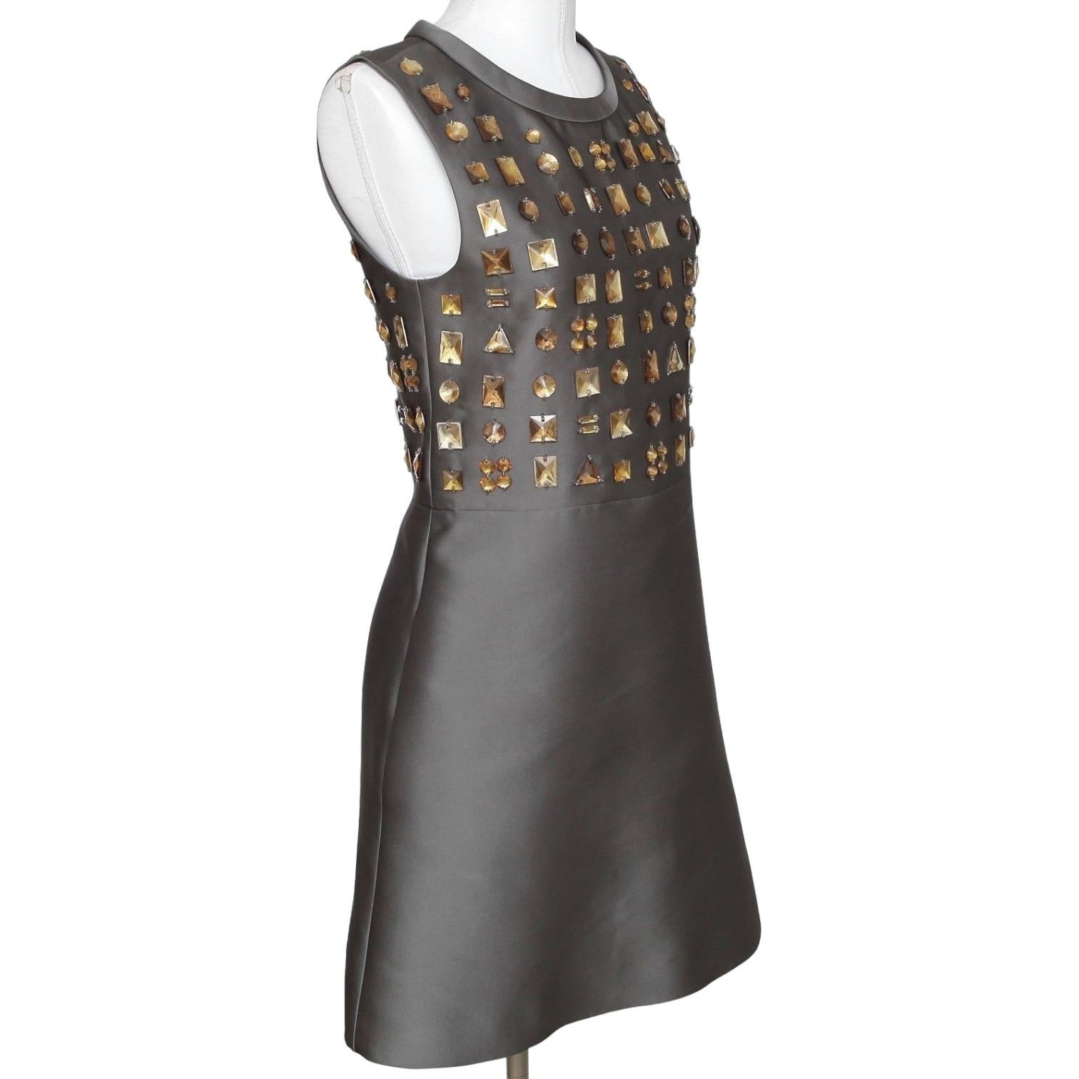GUARANTEED AUTHENTIC CHLOE 2011 COLLECTION EMBELLISHED SLEEVELESS DRESS

Details:
• Stunning A-line sleeveless dress in a metallic grey color.
• Antiqued embellishments at top of dress.
• Crew neckline.
• Concealed rear zipper.
• Fully